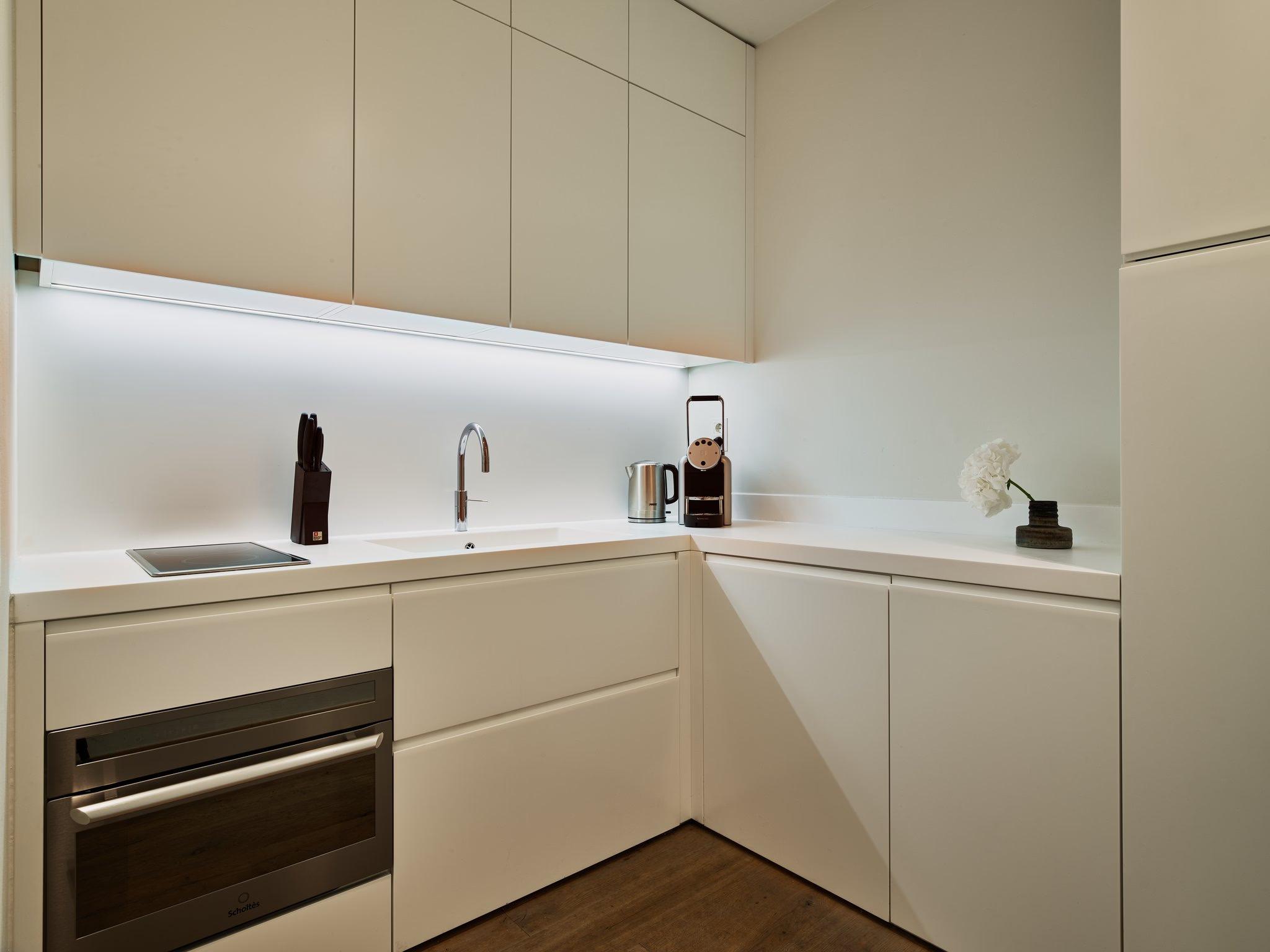Mandarin Oriental Conservatorium, Amsterdam: compact kitchenette with minimalist cabinetry, white countertop, and integrated appliances