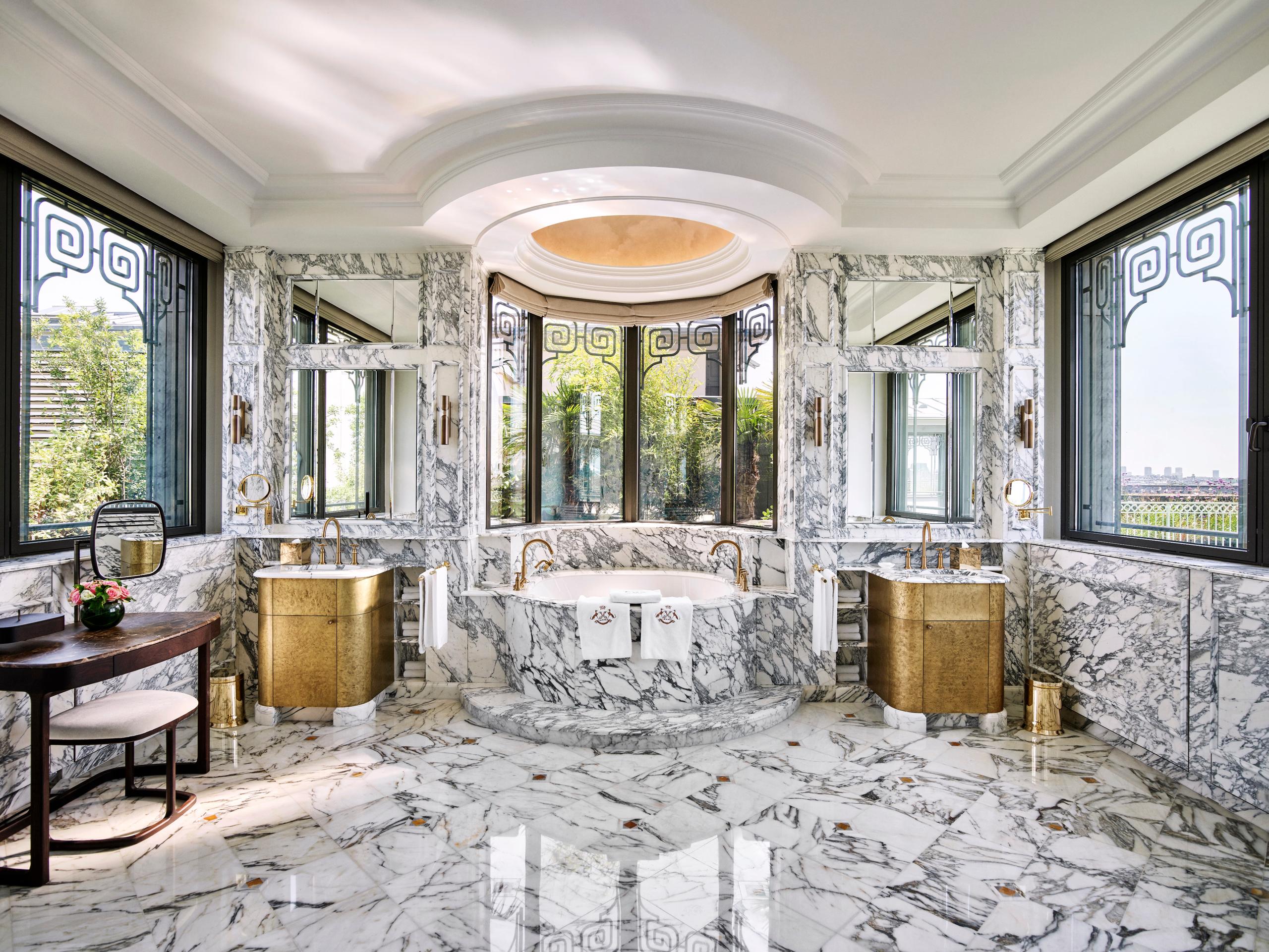 Le Meurice: a marble bathroom with an oversized tub in cream and gilt finishes