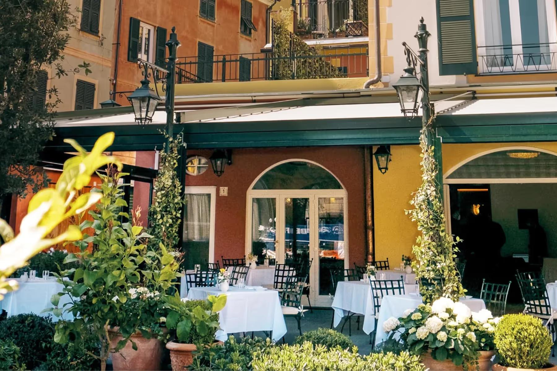 Splendido Mare: colorful restaurant facade with white tables and ivy