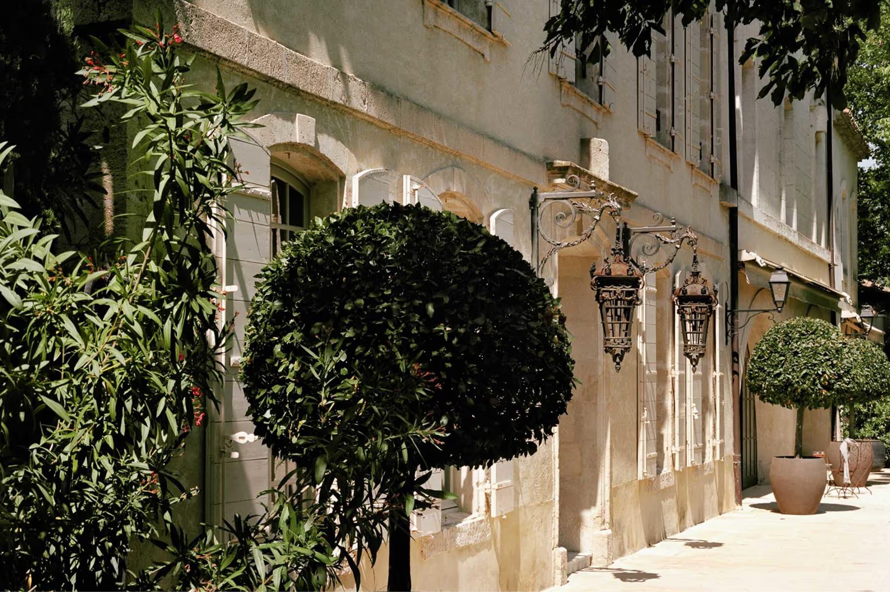 Le Mas de Chabran: sheltered courtyard entrance with potted bay topiaries and stone archways