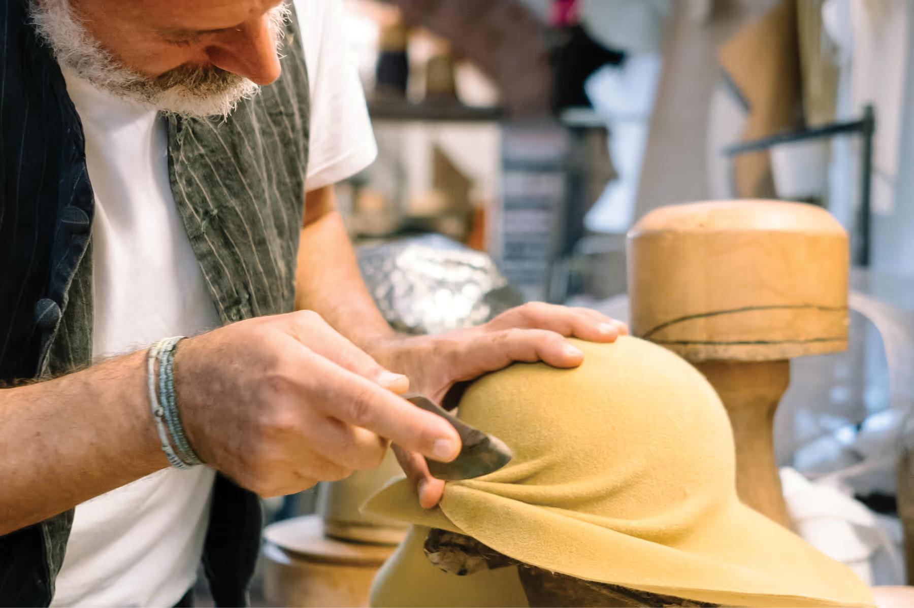 Villa San Michele: hands shaping clay in a pottery workshop with craft materials on work surface