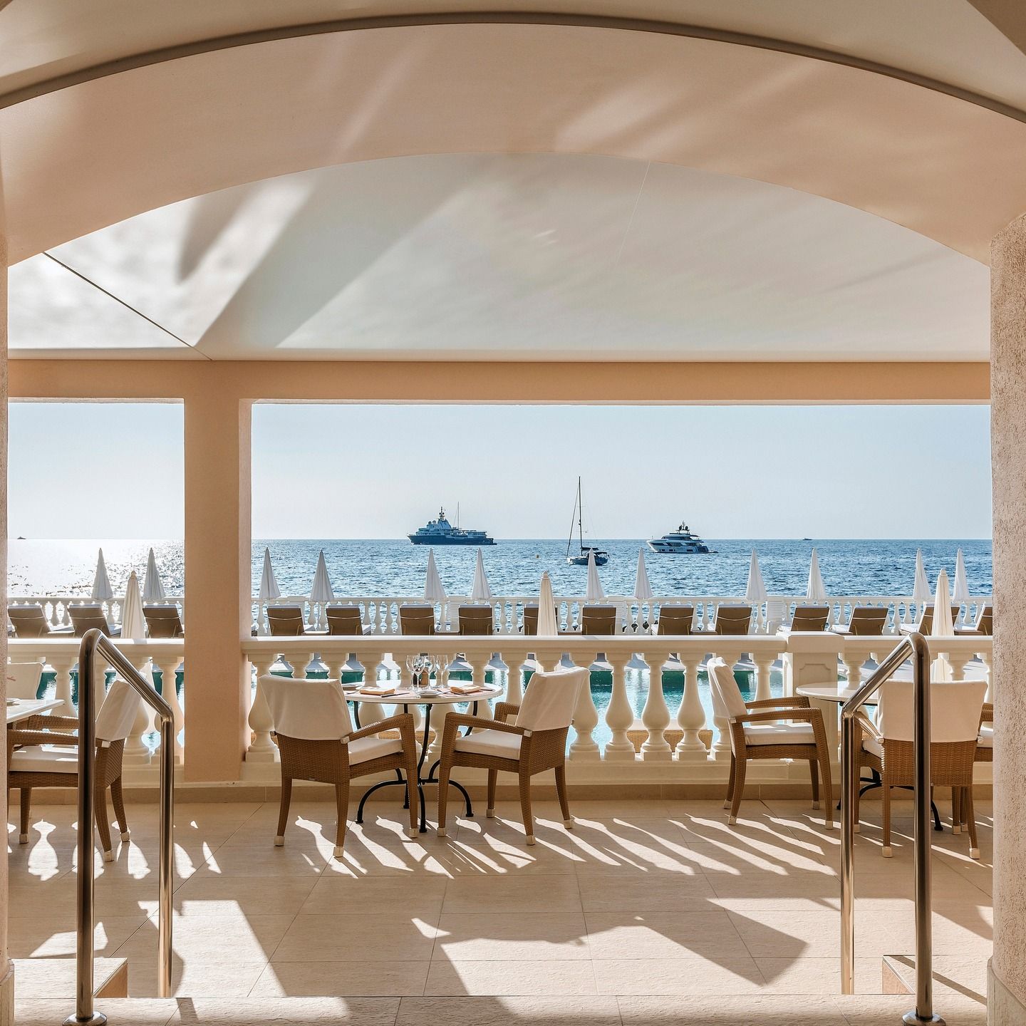 The seafront terrace at La Réserve de Beaulieu, yachts on the water beyond