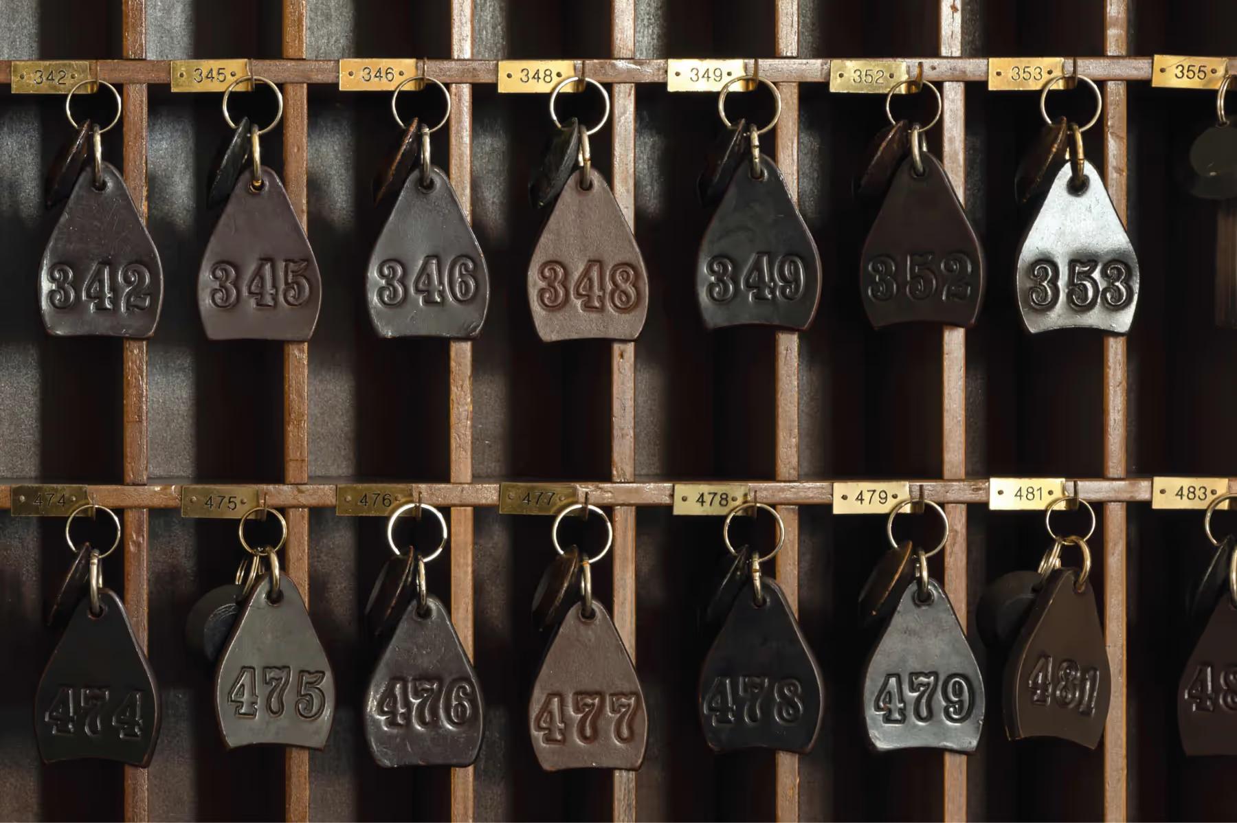 Splendido: numbered brass tags on iron hooks arranged in rows on a wooden board