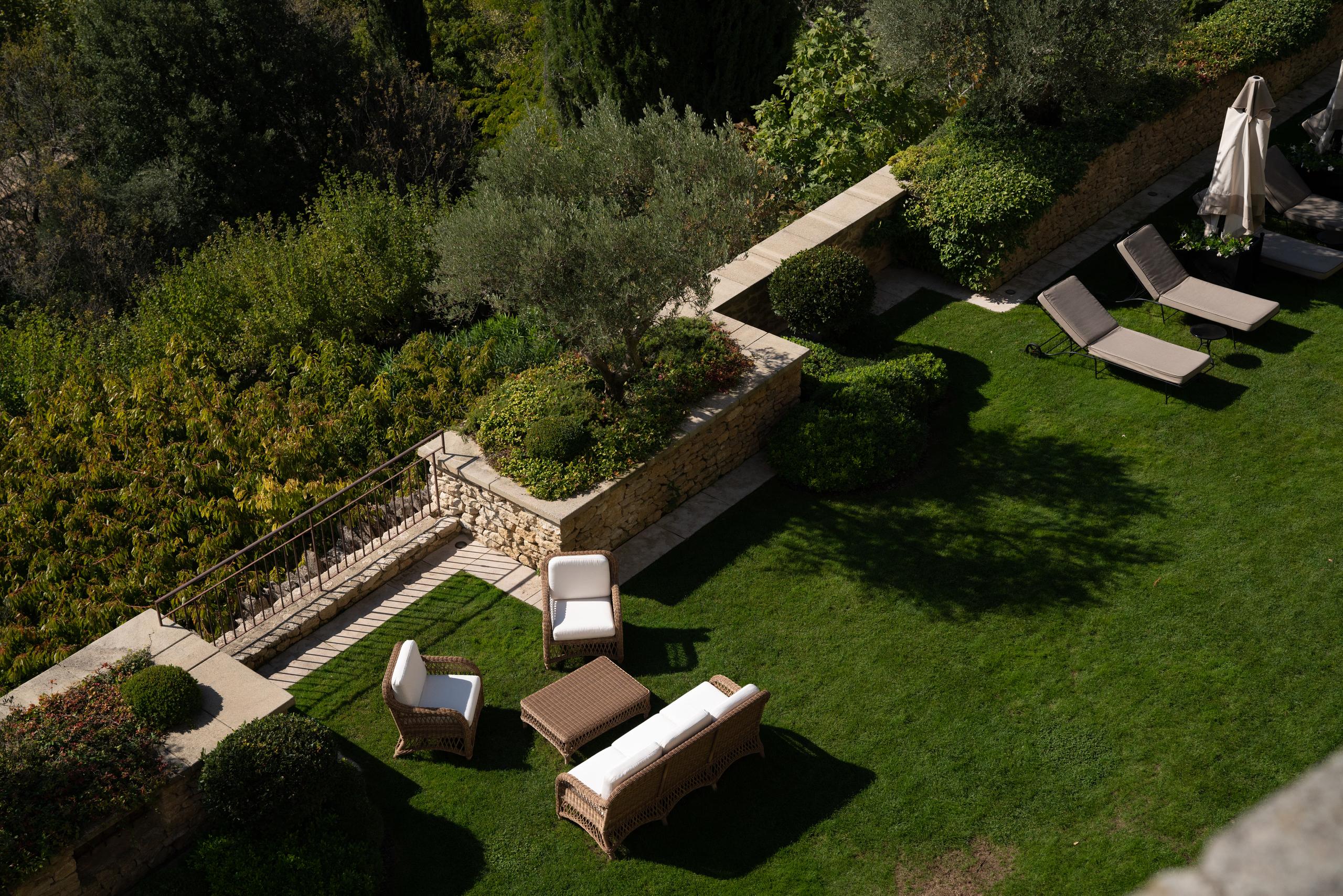 Airelles Gordes, La Bastide: terraced gardens sloping downward with stone walls and cypress punctuating the landscape
