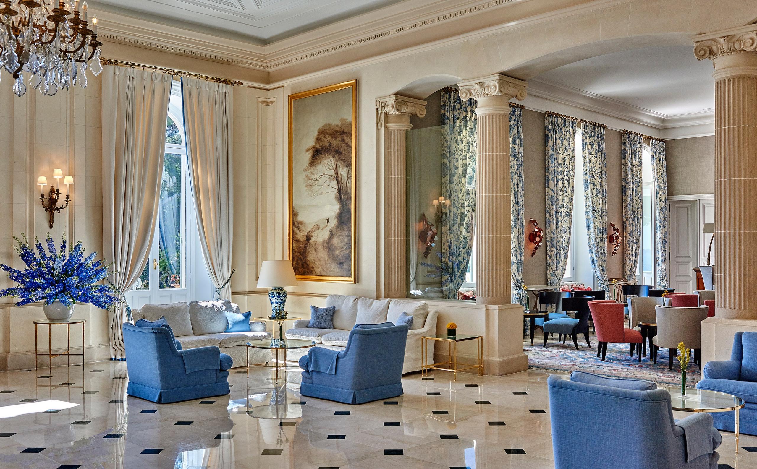 Hôtel du Cap-Eden-Roc: an ornate lounge with blue accents, gold leaf details, arched niches, and windows to the grounds