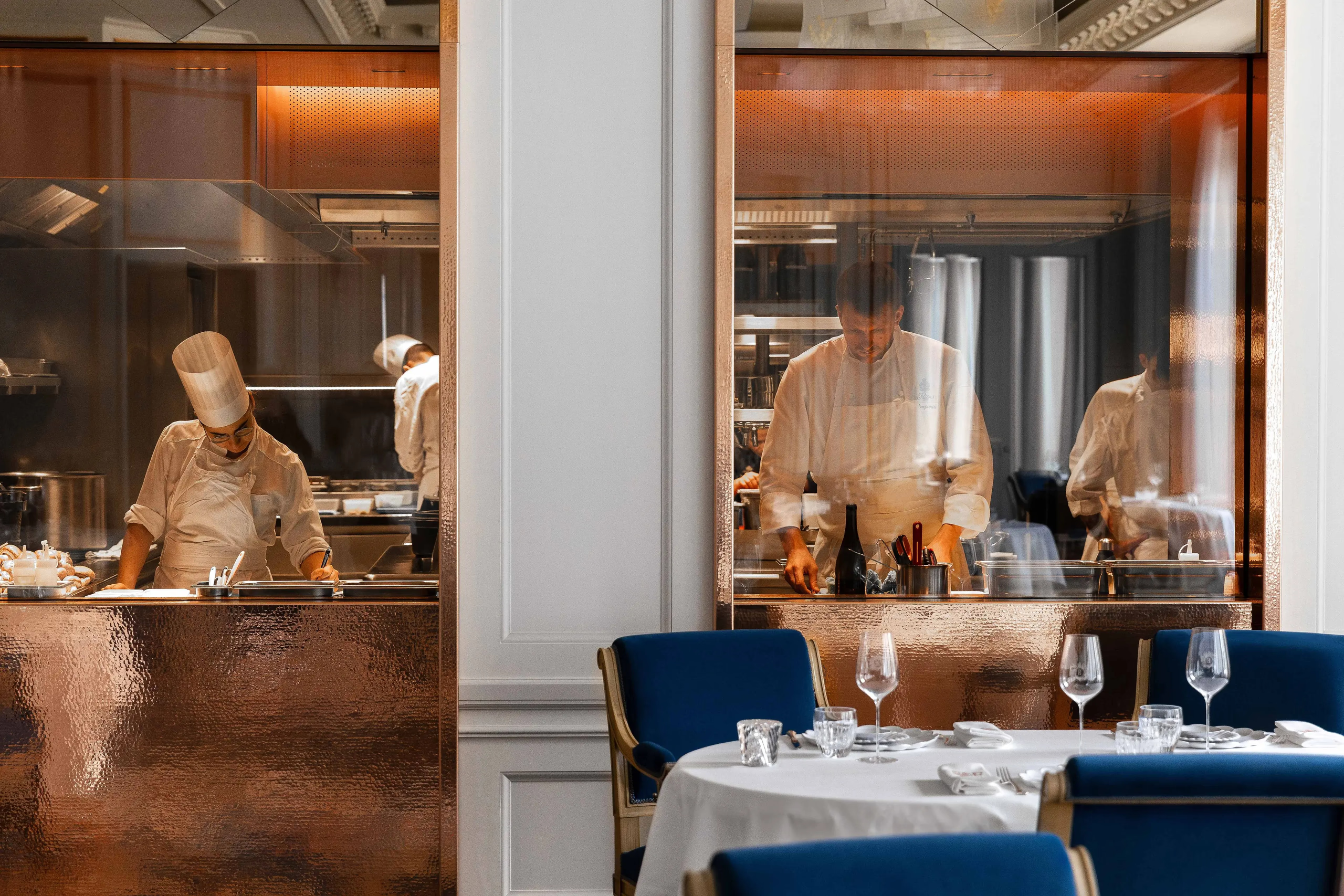 Ritz Paris: a dining room with display cases, blue velvet chairs, and elegant table service