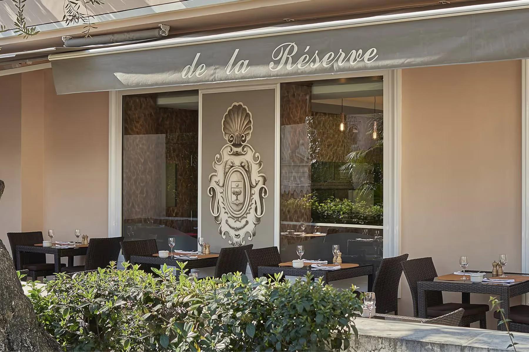La Réserve de Beaulieu: restaurant storefront with signage and outdoor seating area