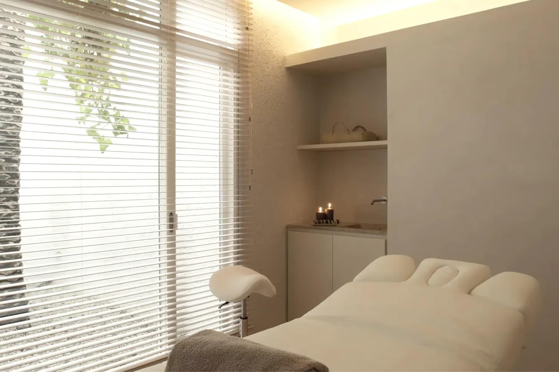 Es Racó d’Artà: spa treatment room with daybed, window blinds, and built-in shelving