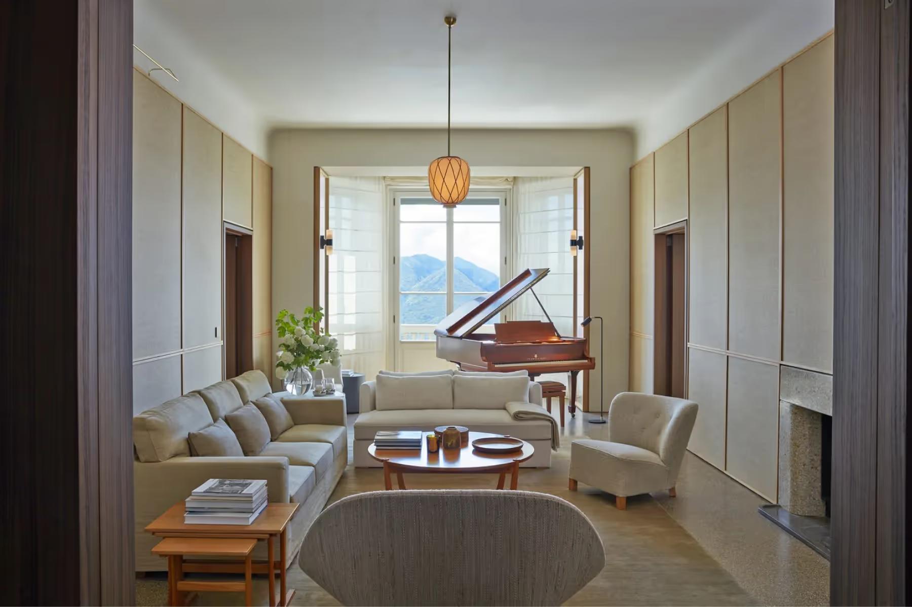 Villa Patrizia: a salon with cream walls, tall windows, a wooden piano, and traditional furnishings