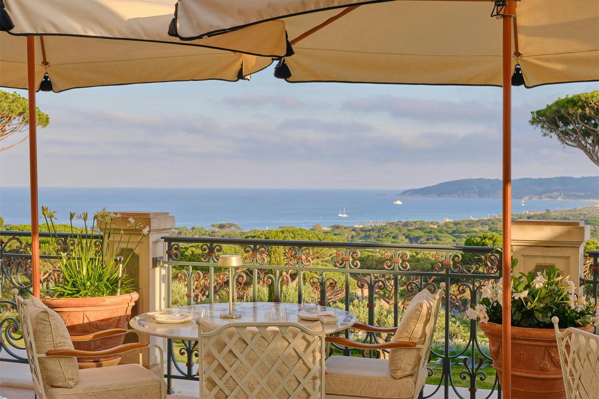 Château de La Messardière: outdoor dining table under cream canvas awning with rolled-up sides and distant sea horizon