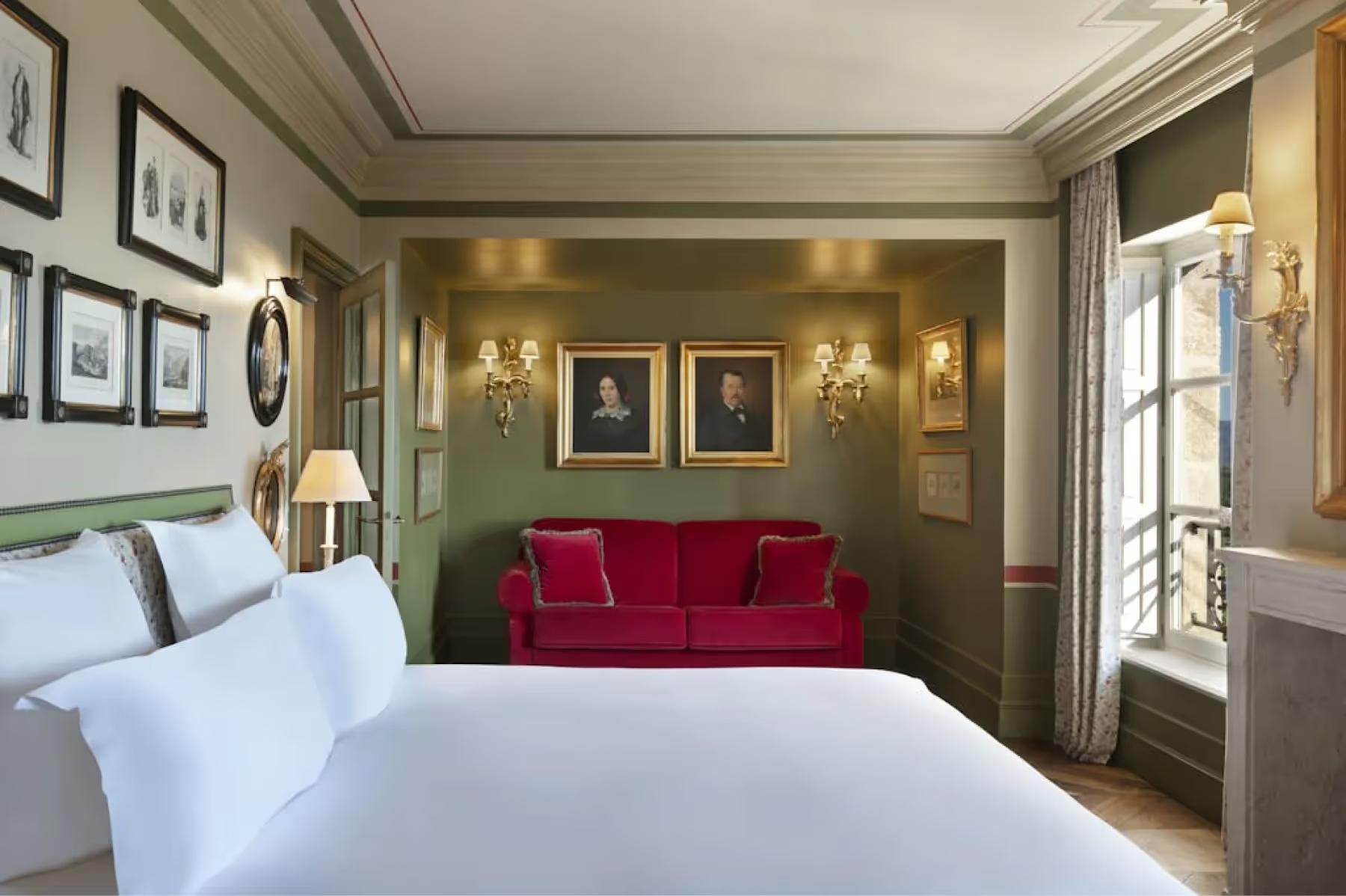 Airelles Gordes, La Bastide: suite with sage green accent wall, red velvet seating, and terrace access