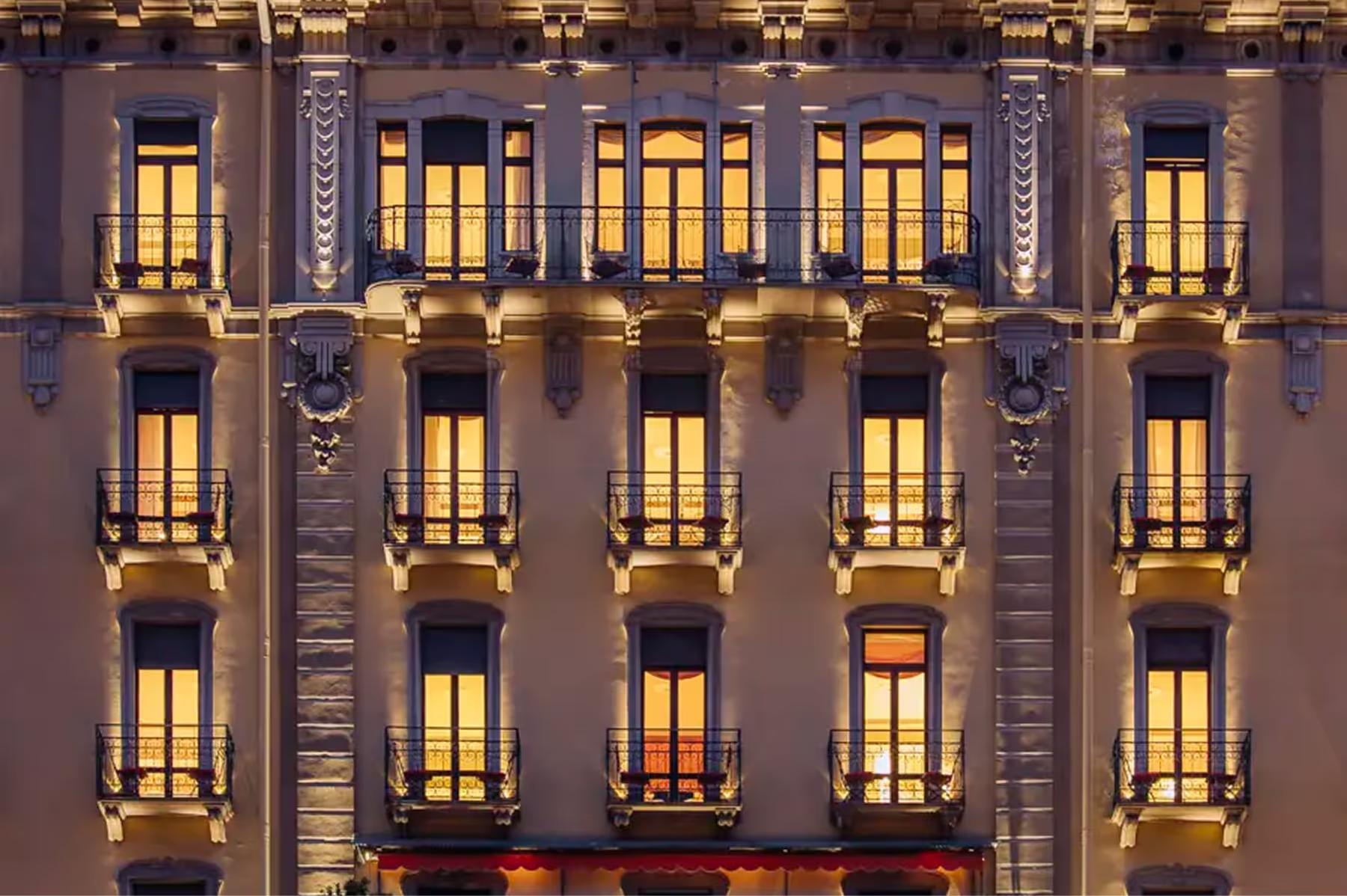 Hotel facade at night with lit windows in symmetrical rows