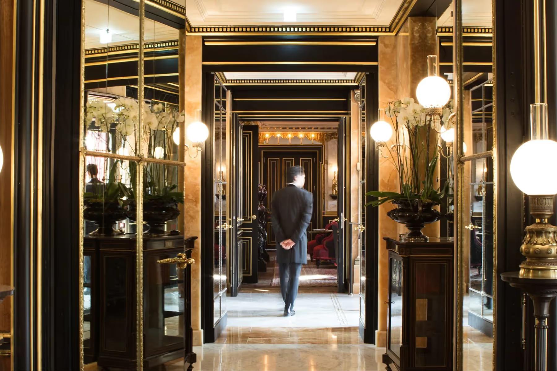 La Réserve Paris: an interior hallway with dark wood panels and hanging globe lights