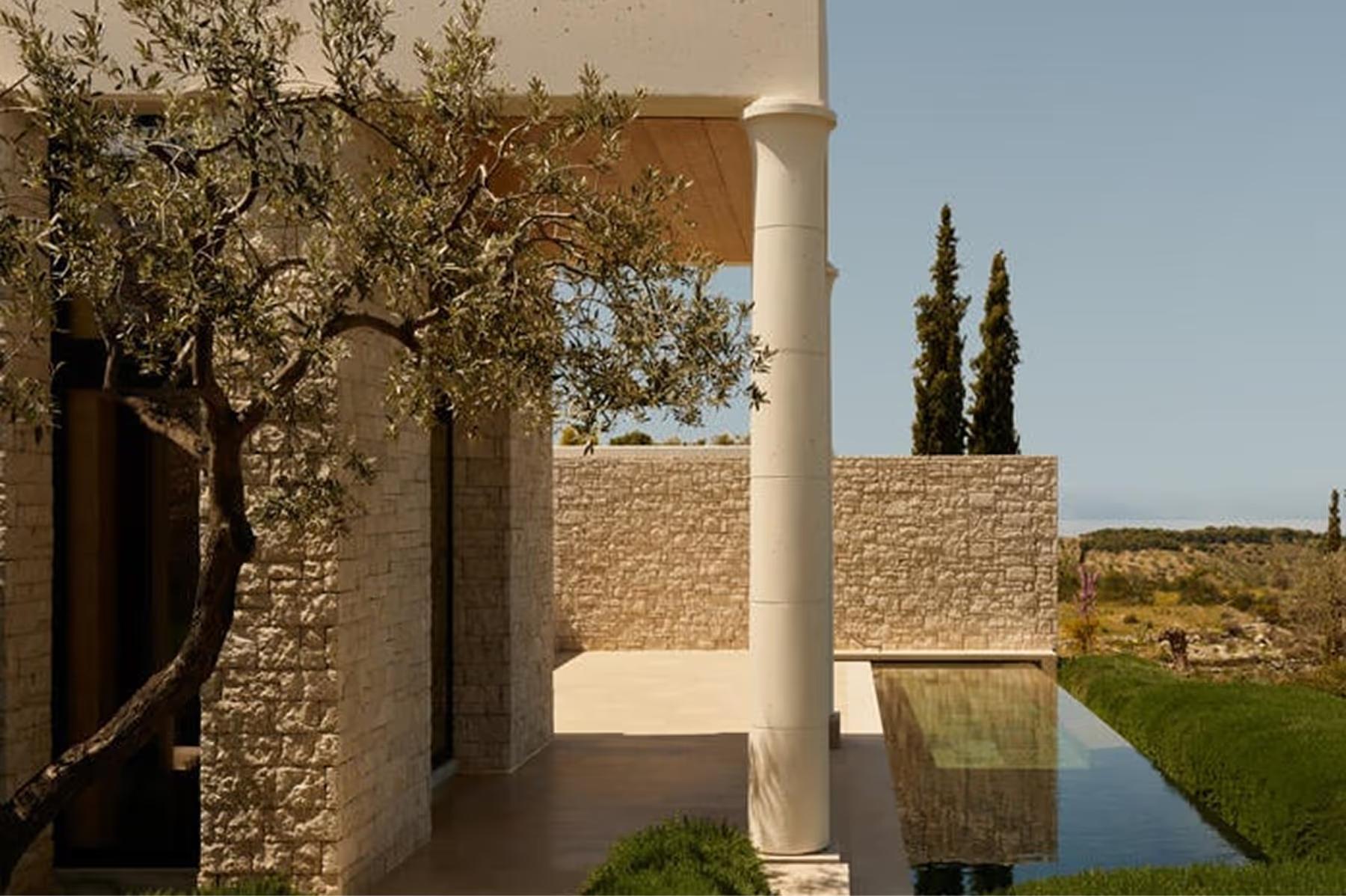 Amanzoe: terraced garden space with olive trees and modern stone architecture
