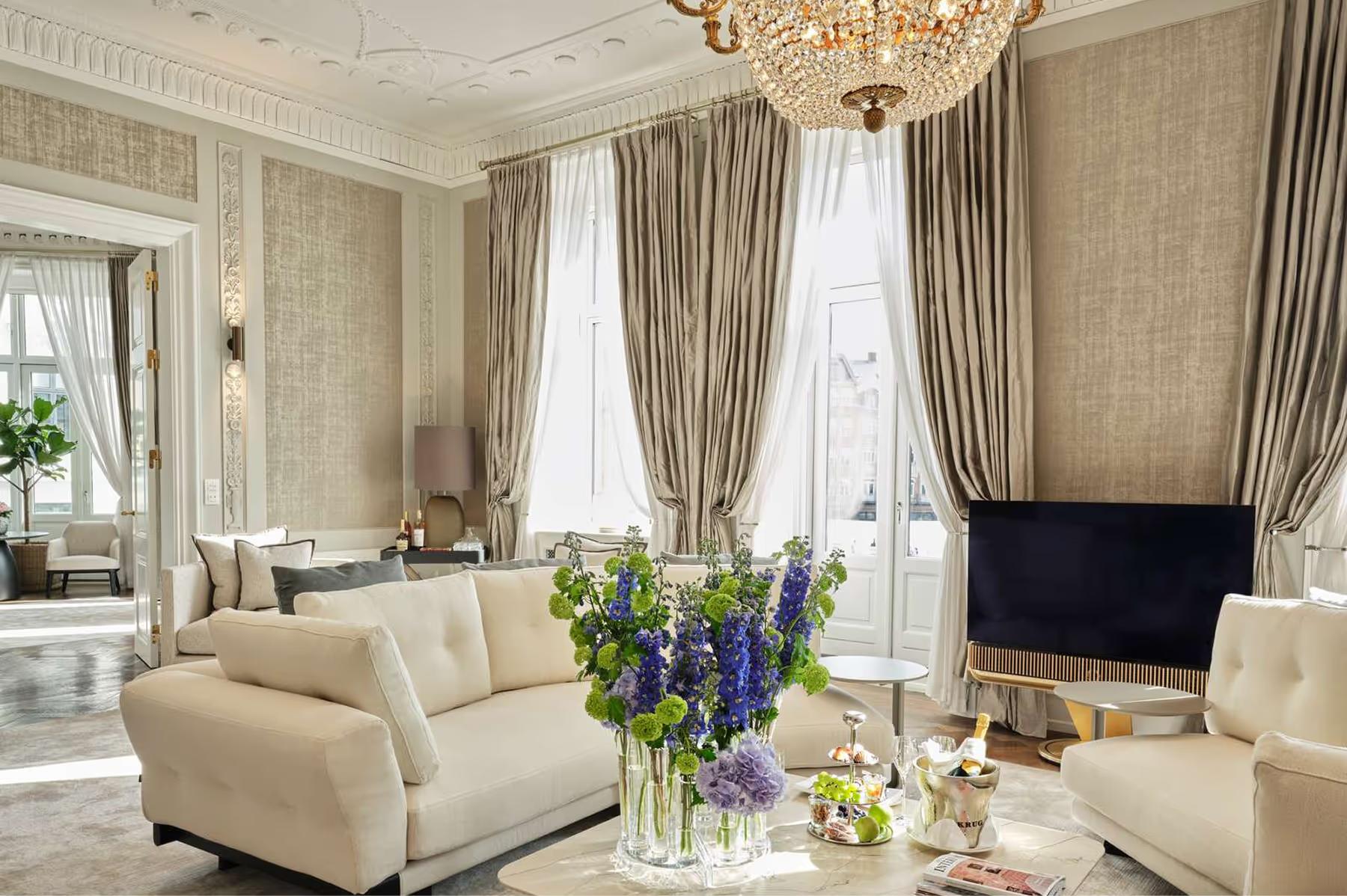 Seating area with cream sofa, arched windows and golden ceiling light