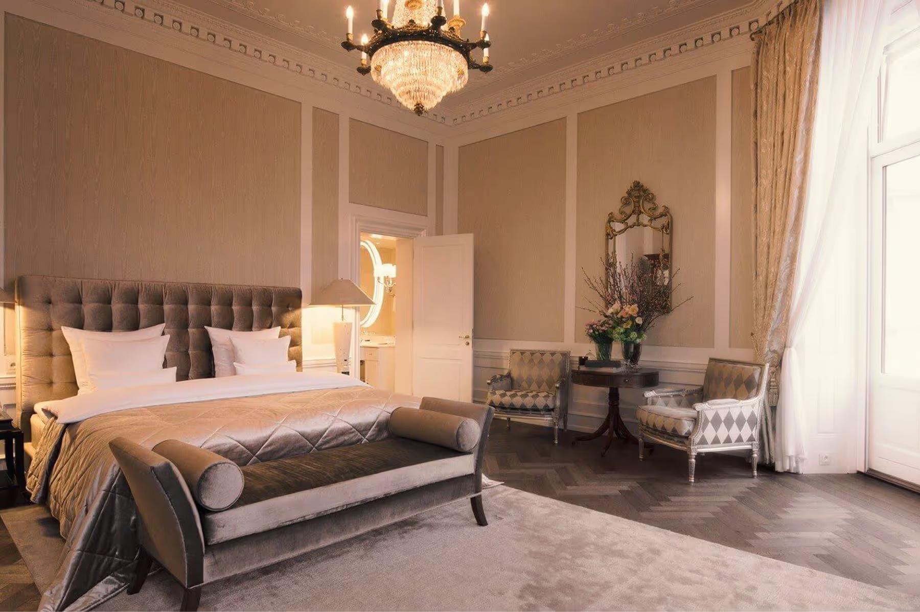 Bedroom in dusty rose tones with upholstered headboard and pendant lights