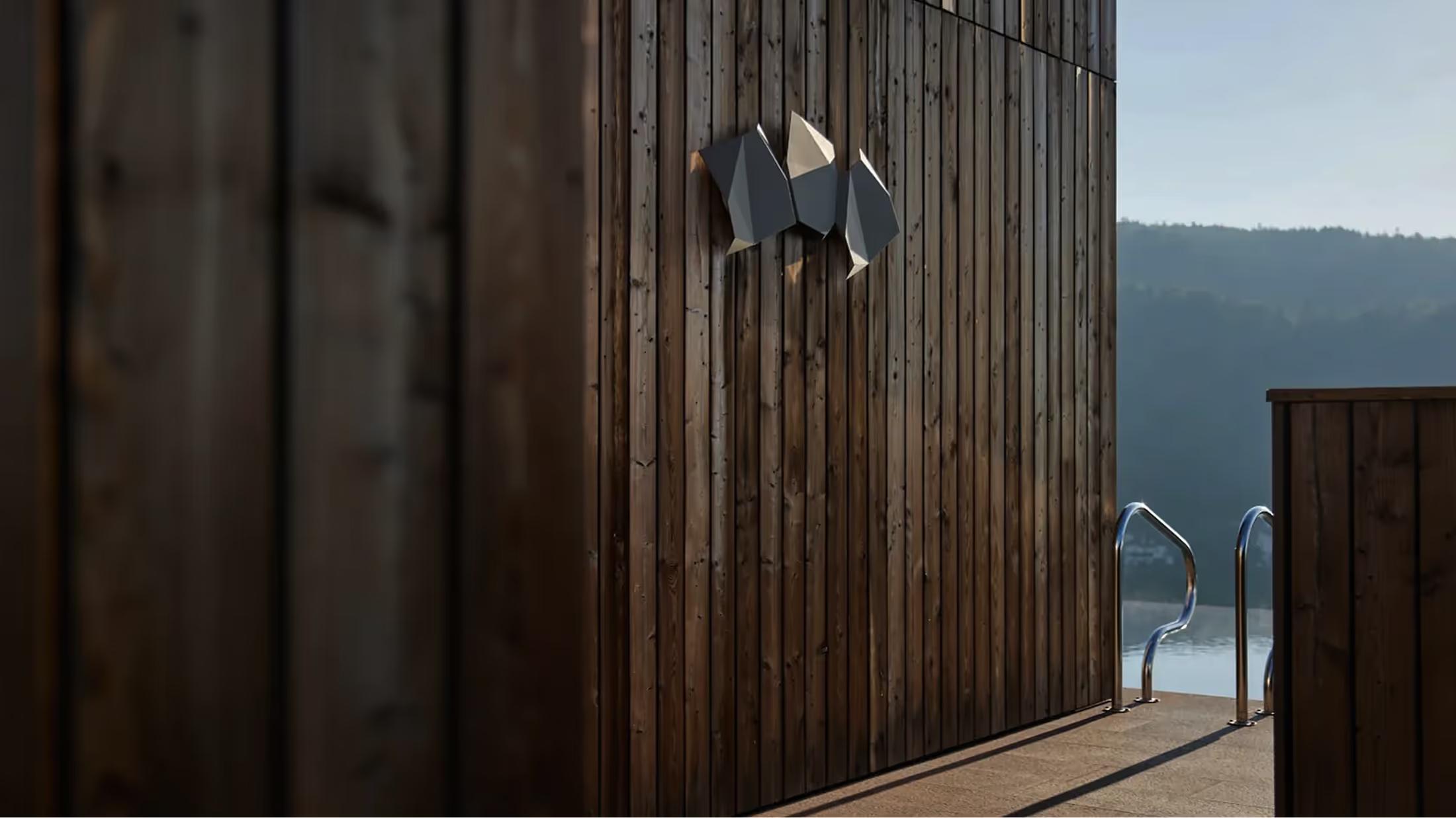 Wooden exterior wall and deck with mountains visible through the glass doors at dusk