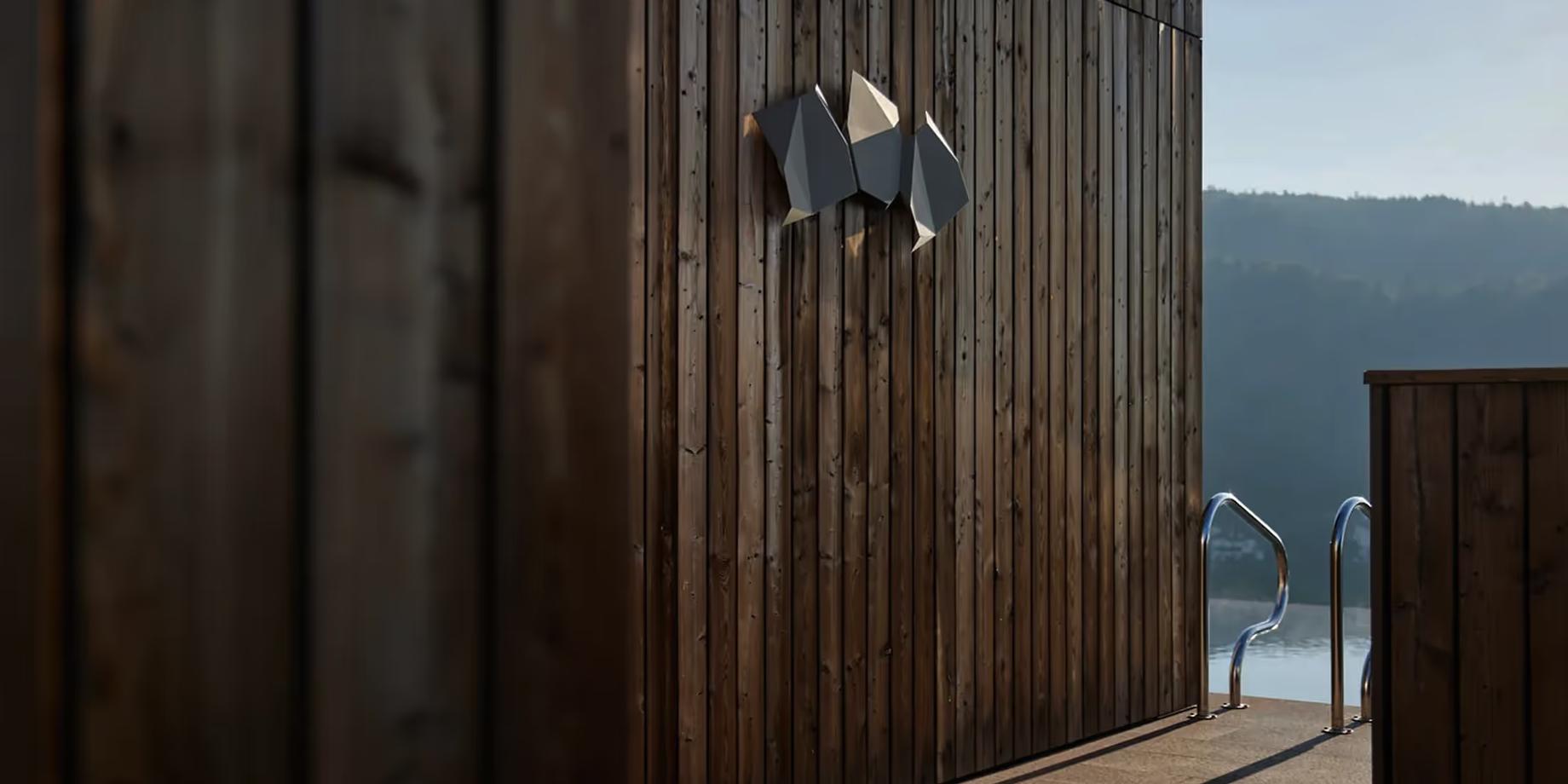 Wooden exterior wall and deck with mountains visible through the glass doors at dusk