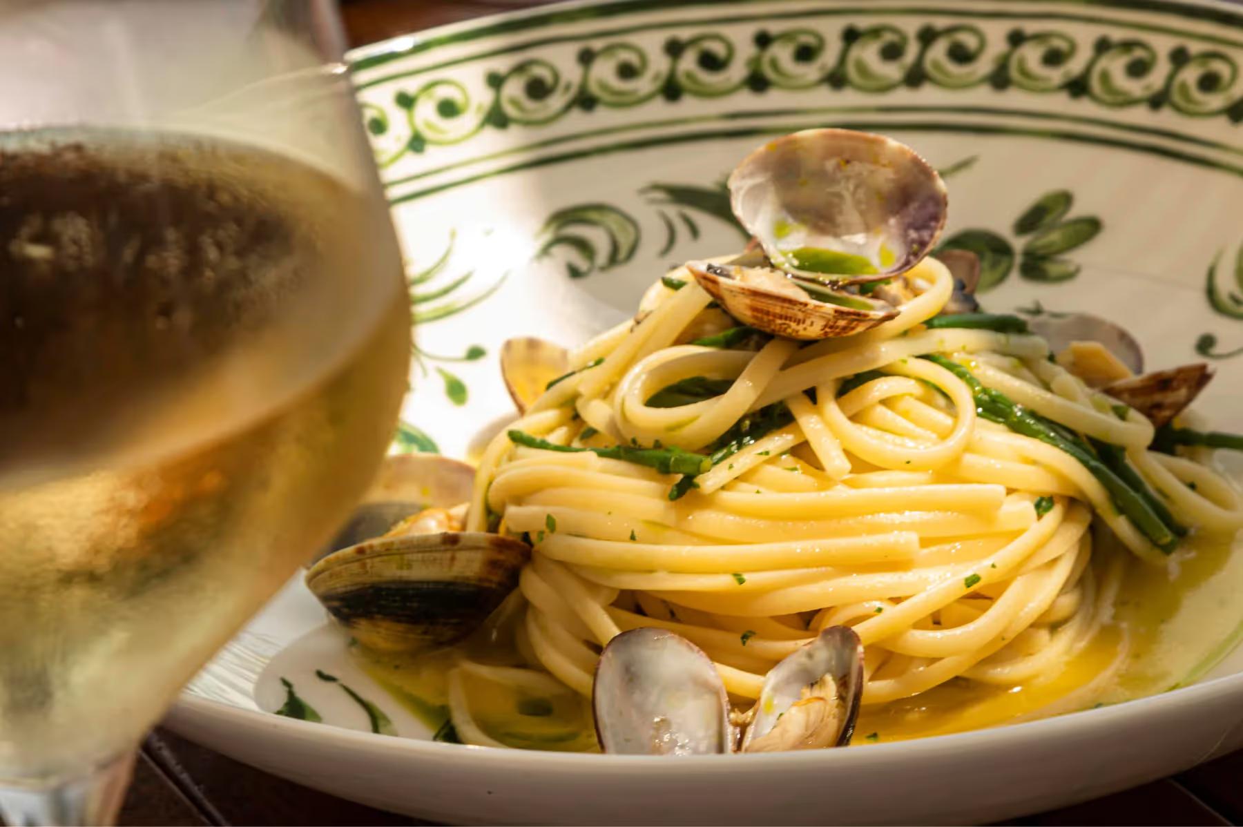 Splendido: handmade fresh pasta on a decorative plate with herbs and coastal light