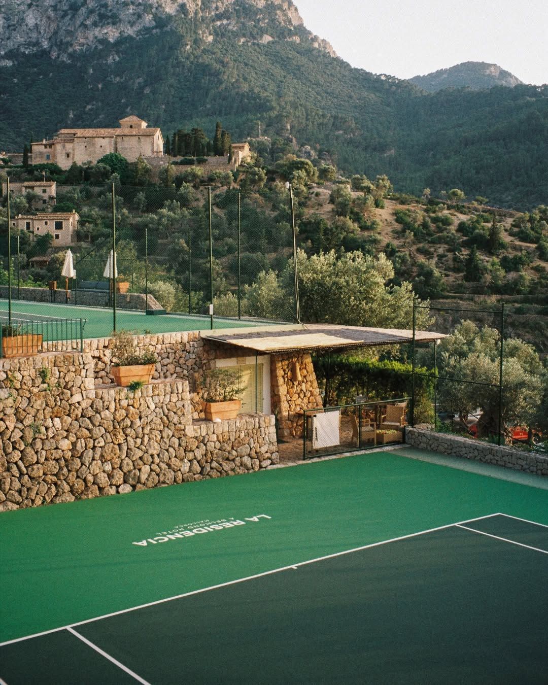 A green hard court below the Tramuntana mountains at La Residencia, Deià