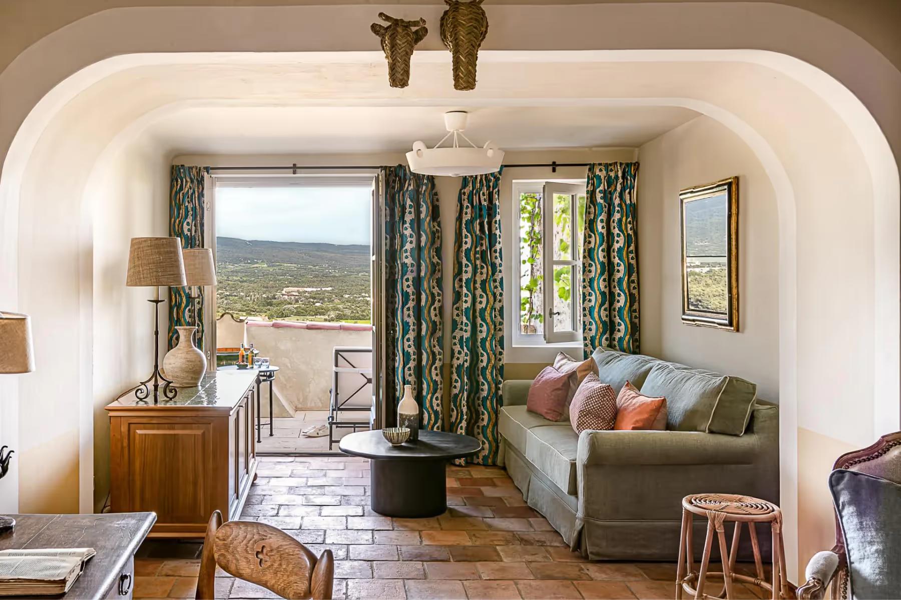 Hôtel Crillon le Brave: a room with an arched alcove bathing area, green patterned curtains, and countryside views through arched windows