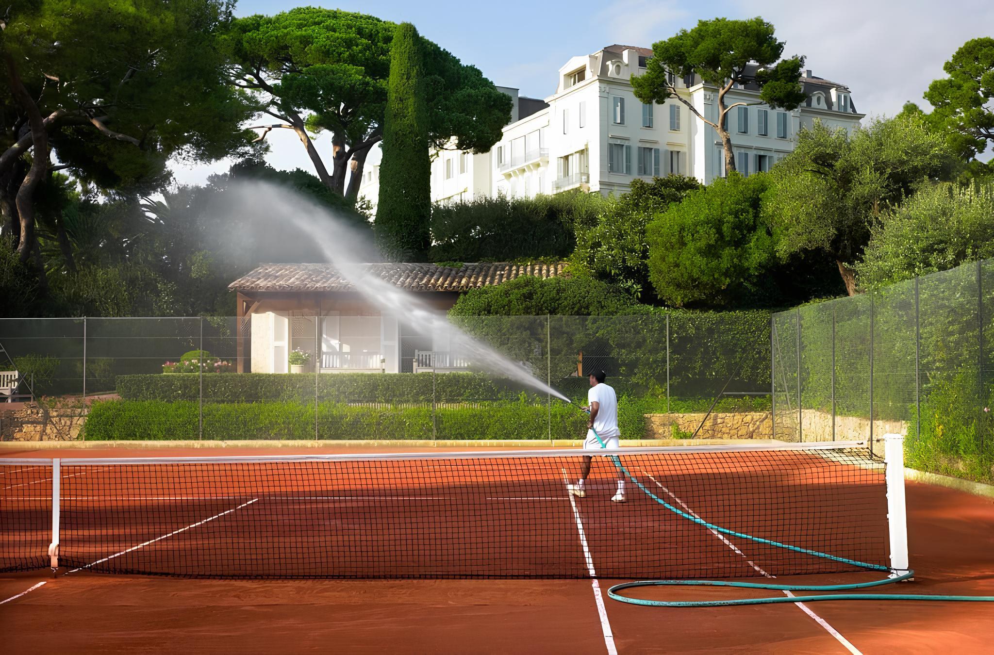 Hôtel du Cap-Eden-Roc: an aerial view of red clay tennis courts set in pine forest on the Riviera estate
