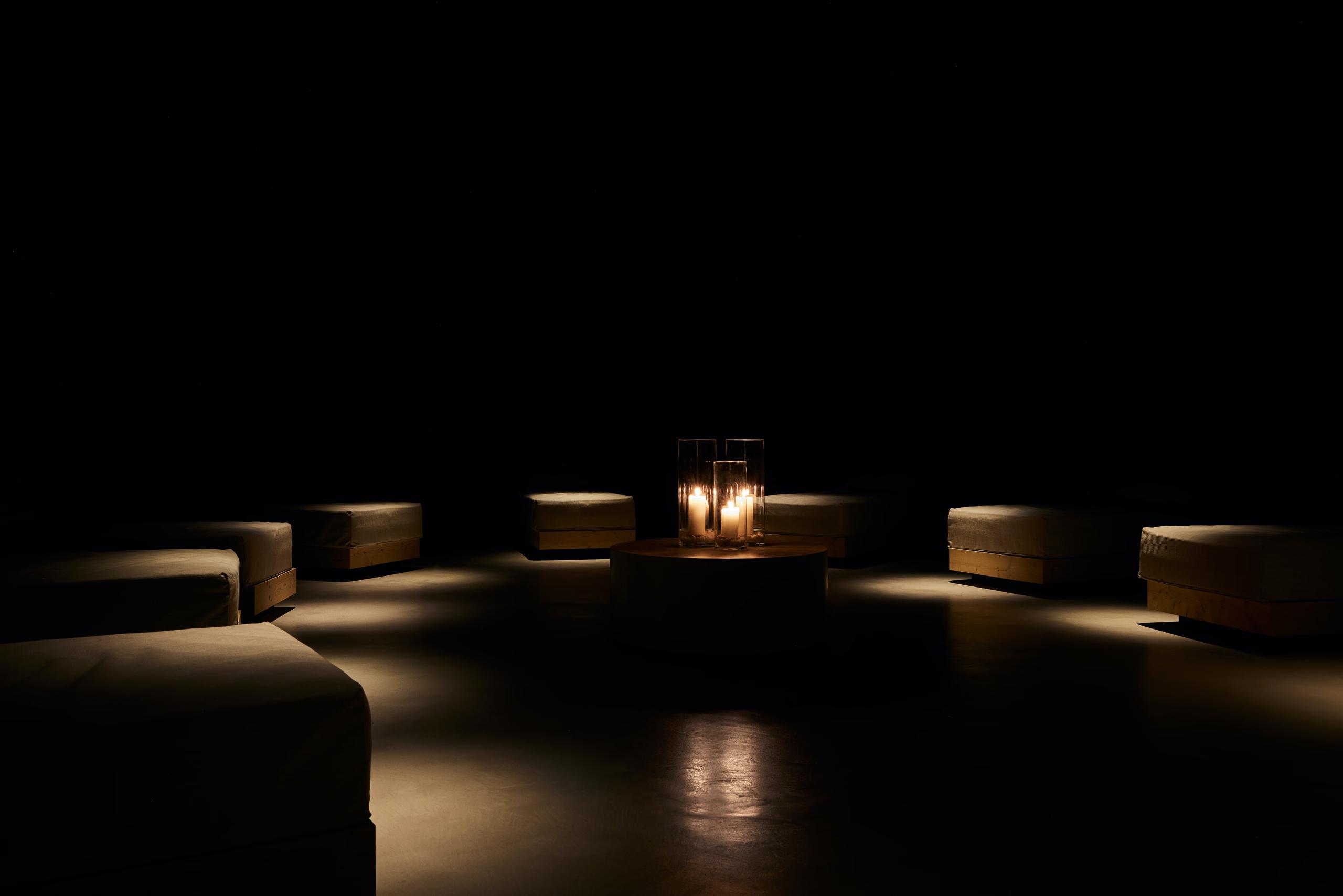 A sauna or wellness room with light wood walls, bench seating, and minimalist architectural details