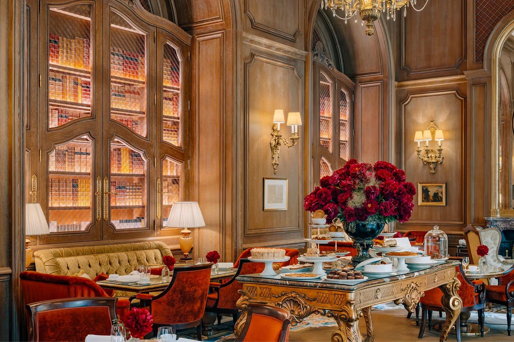 Ritz Paris: a dining room with wood cabinetry, red upholstered chairs, and floral arrangements