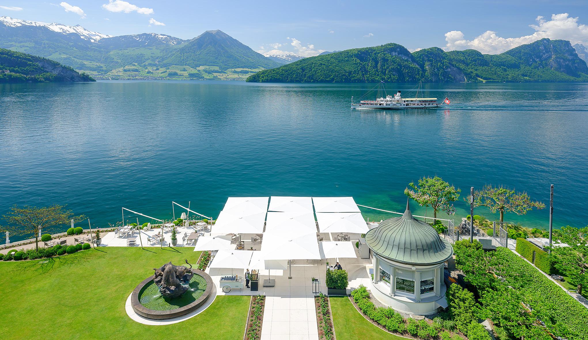 Hotel rooftop view overlooking lake with Alps and rowing boats visible