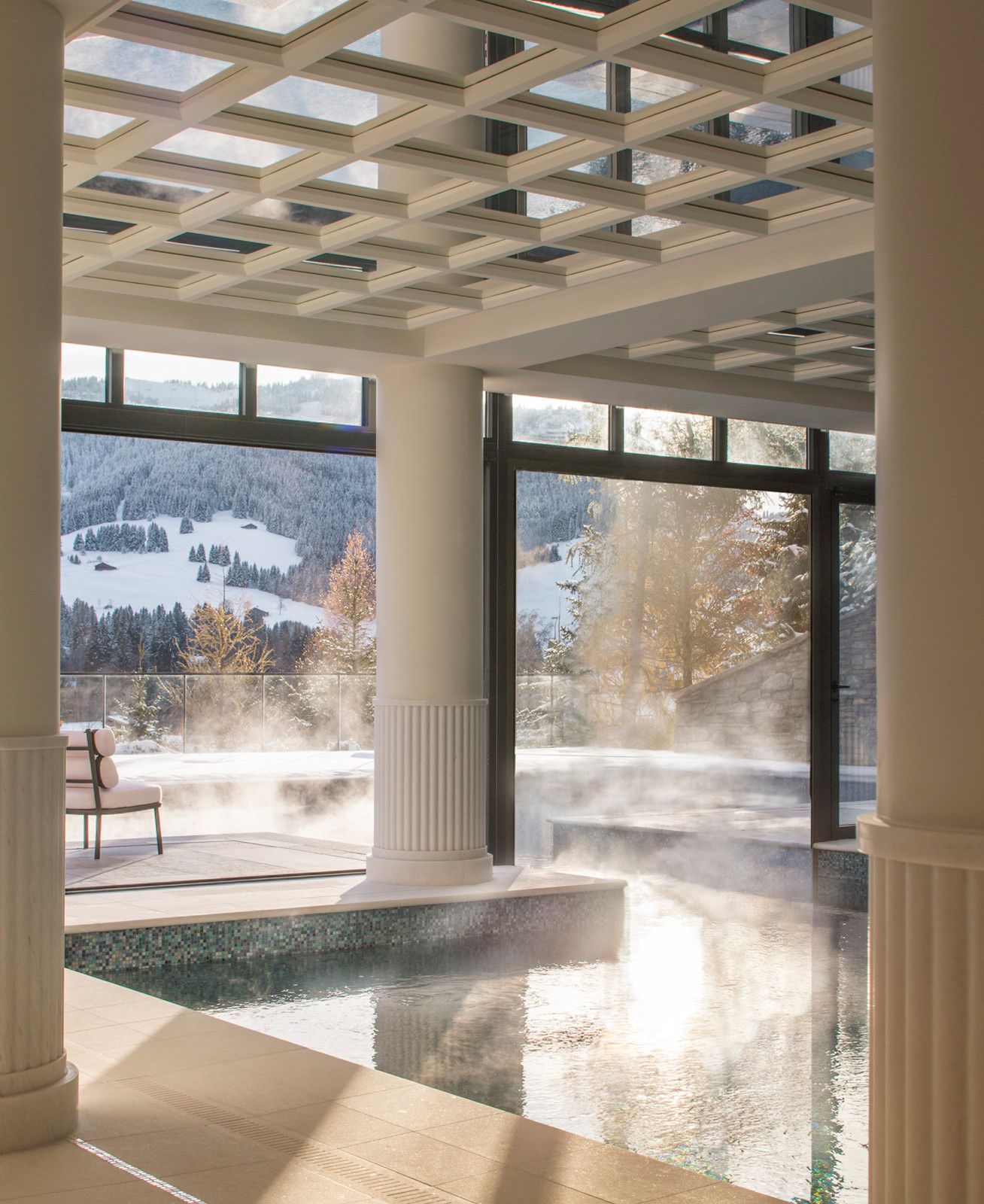The indoor pool at Four Seasons Resort Megève under a white coffered ceiling