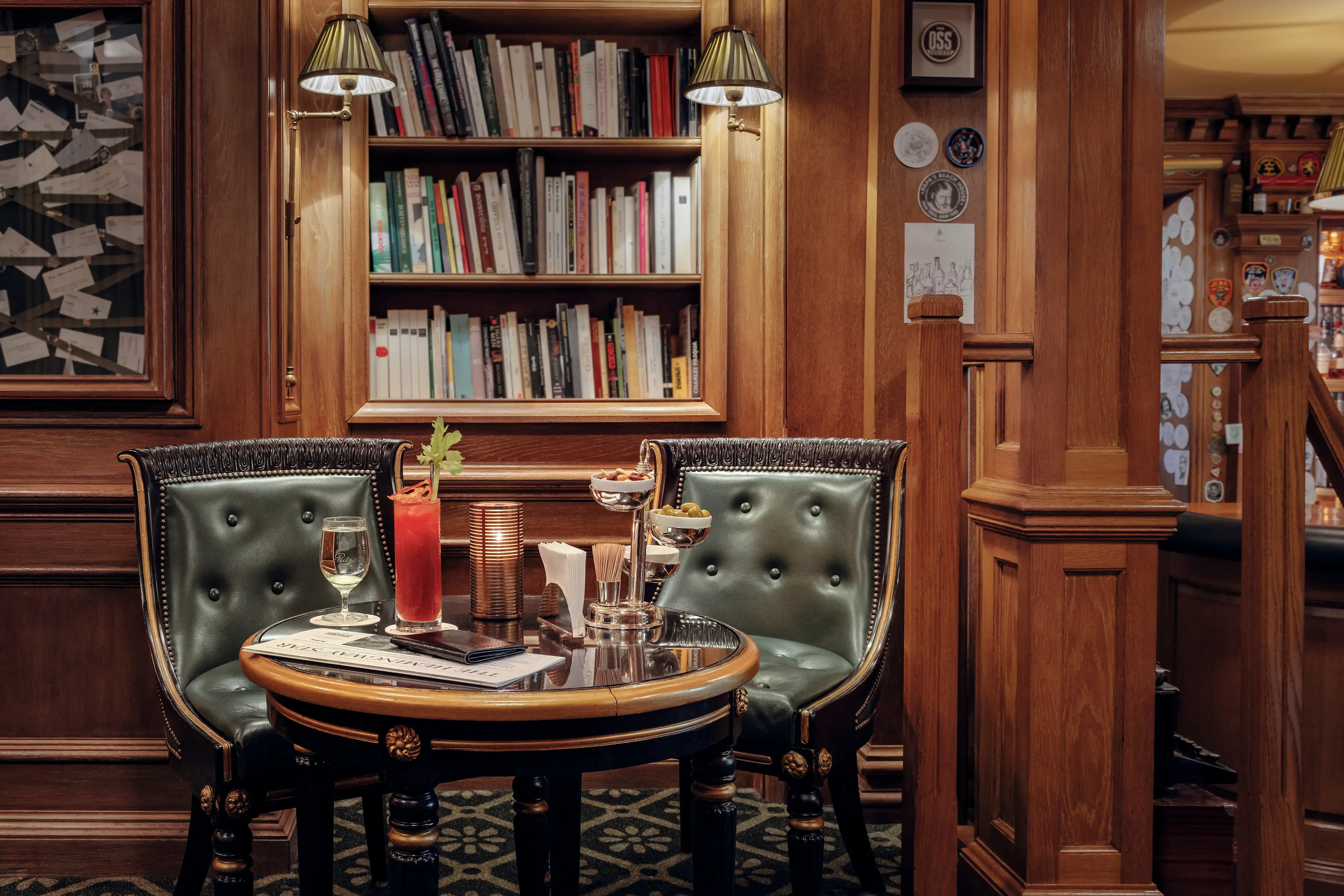 Ritz Paris: a library lounge with green leather chairs, wooden cabinetry, and intimate round table