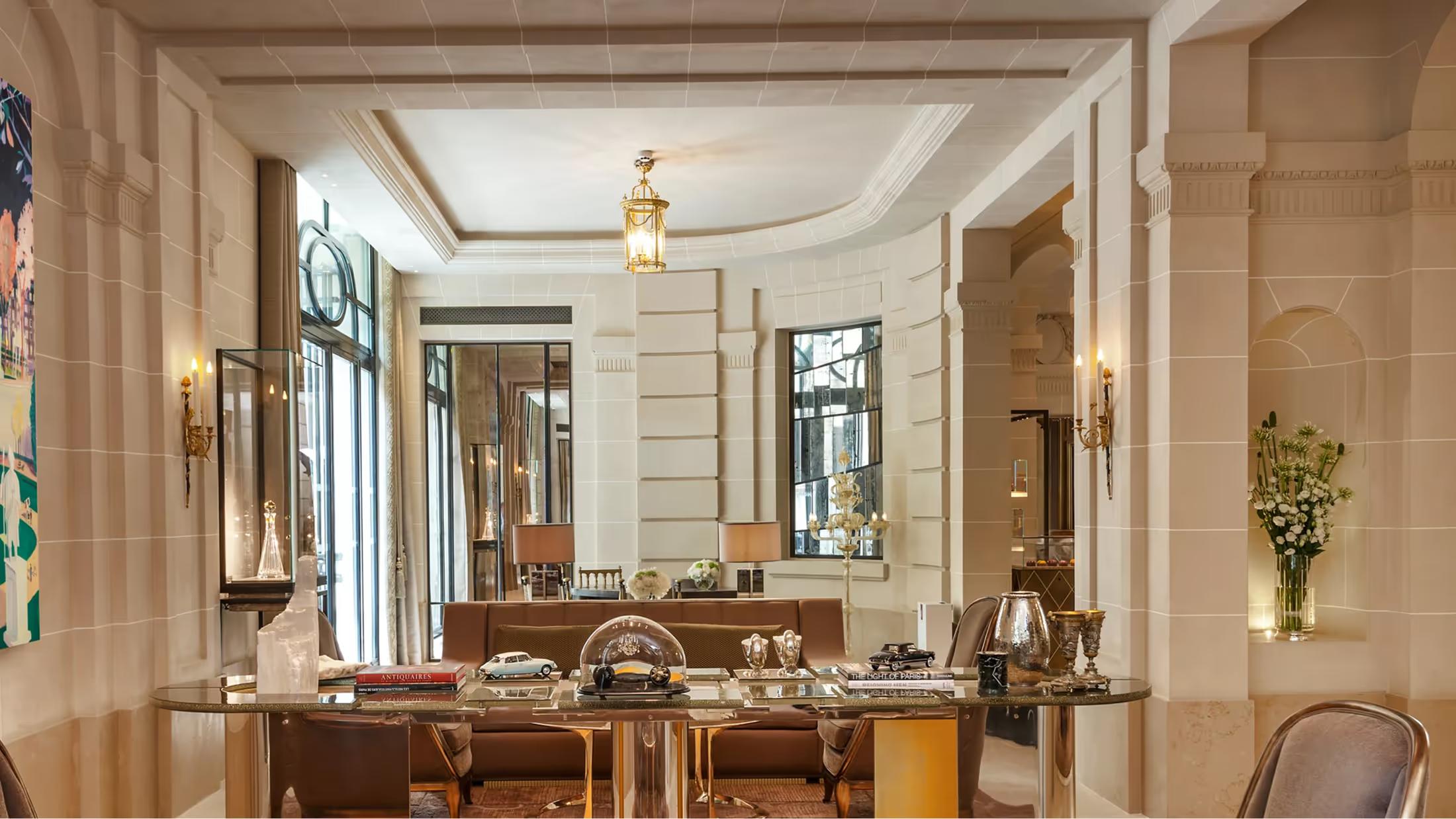 Elegant salon with pale walls, gold-framed mirror, and marble fireplace