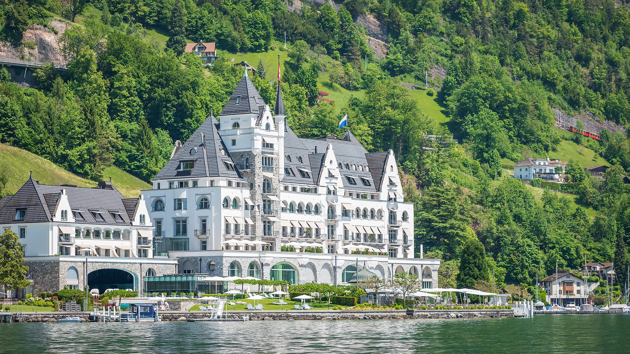 Ornate castle facade viewed from the lake with manicured waterfront