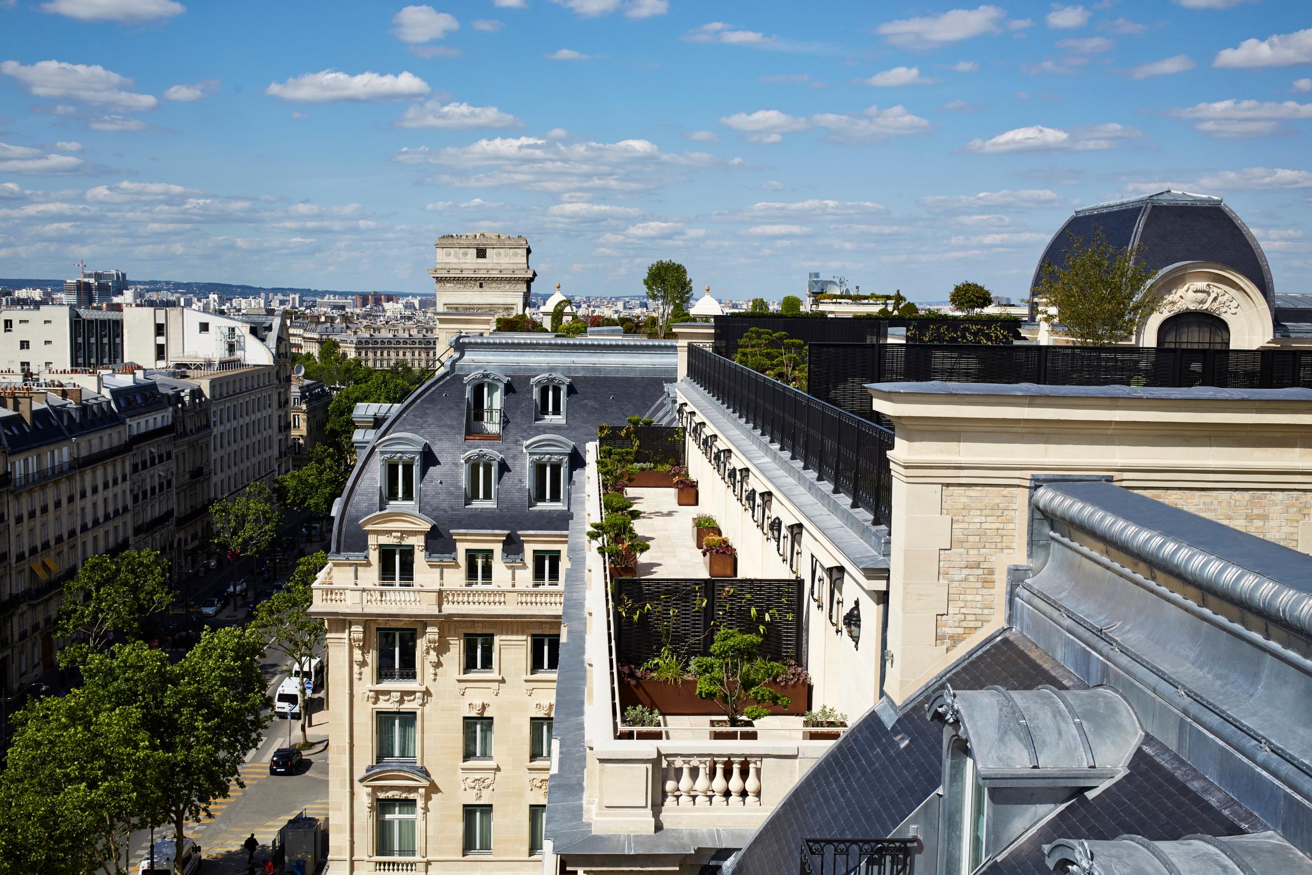 The Peninsula: aerial view of Parisian roofscape with historic buildings and clear sky