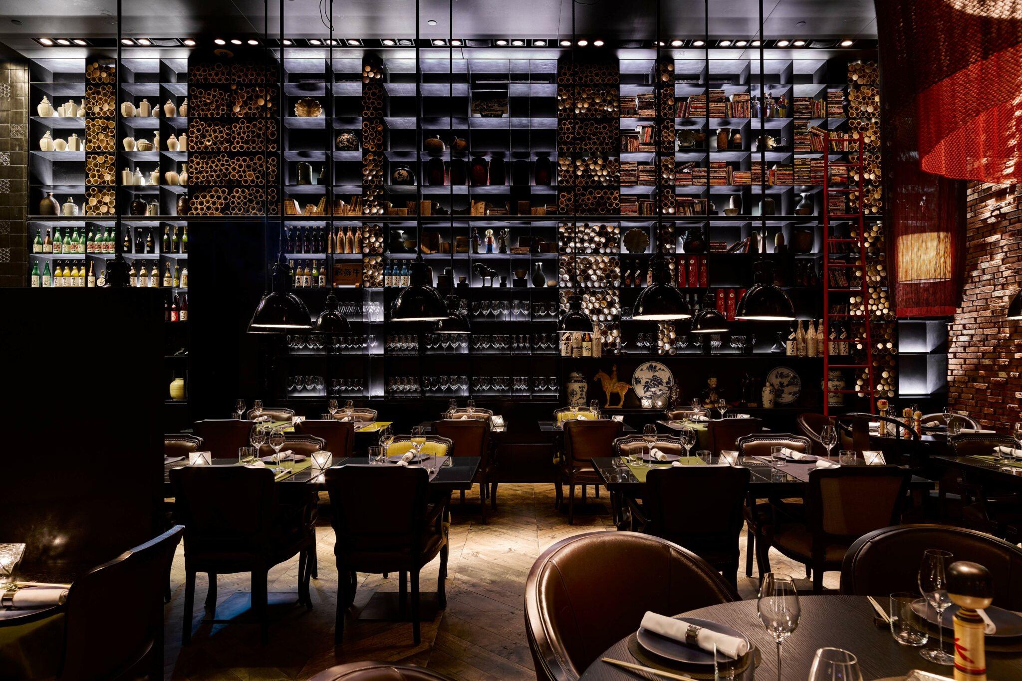 Mandarin Oriental Conservatorium, Amsterdam: Taiko Bar with dark wood cabinetry displaying spirits, leather seating, and mood lighting