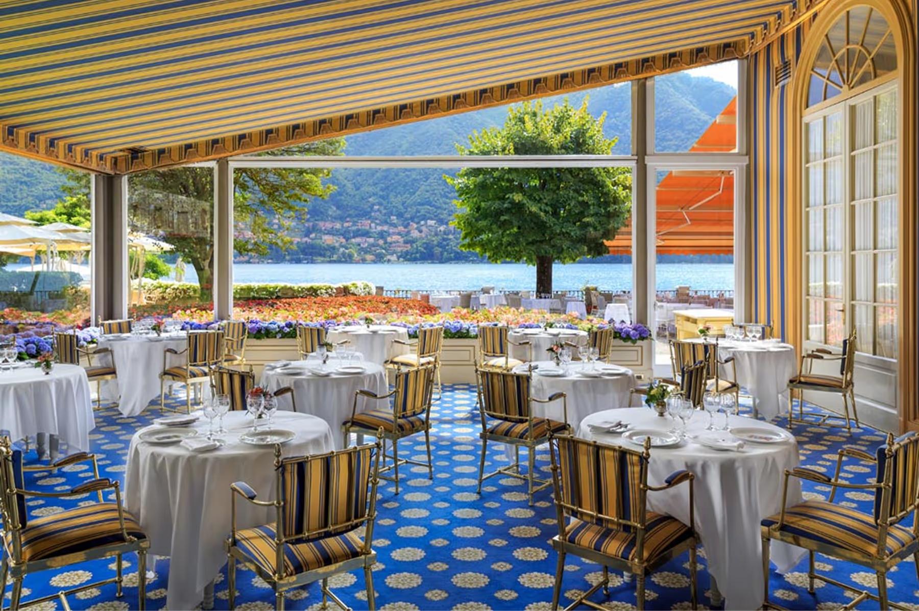 Villa d’Este: formal dining room with white linens, striped chairs, and views of formal gardens