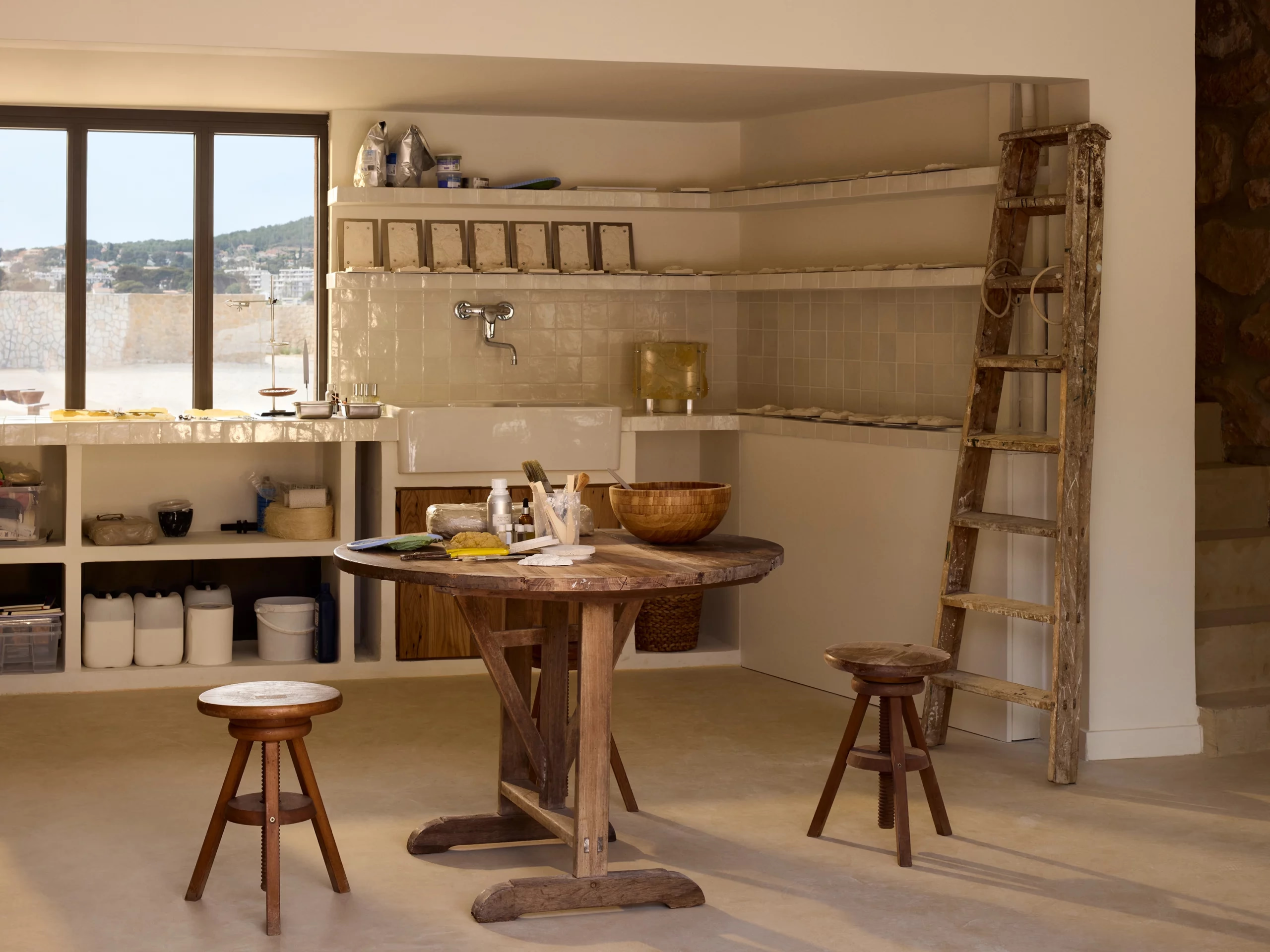 Zannier Île de Bendor: a pottery atelier holds a round worktable, ceramic bowls and a weathered wooden ladder