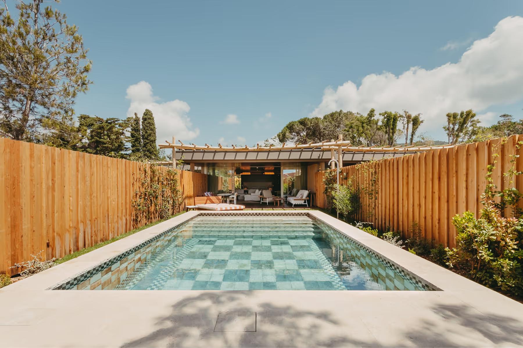 Lily of the Valley: pool with turquoise water tile pattern framed by wooden pergola