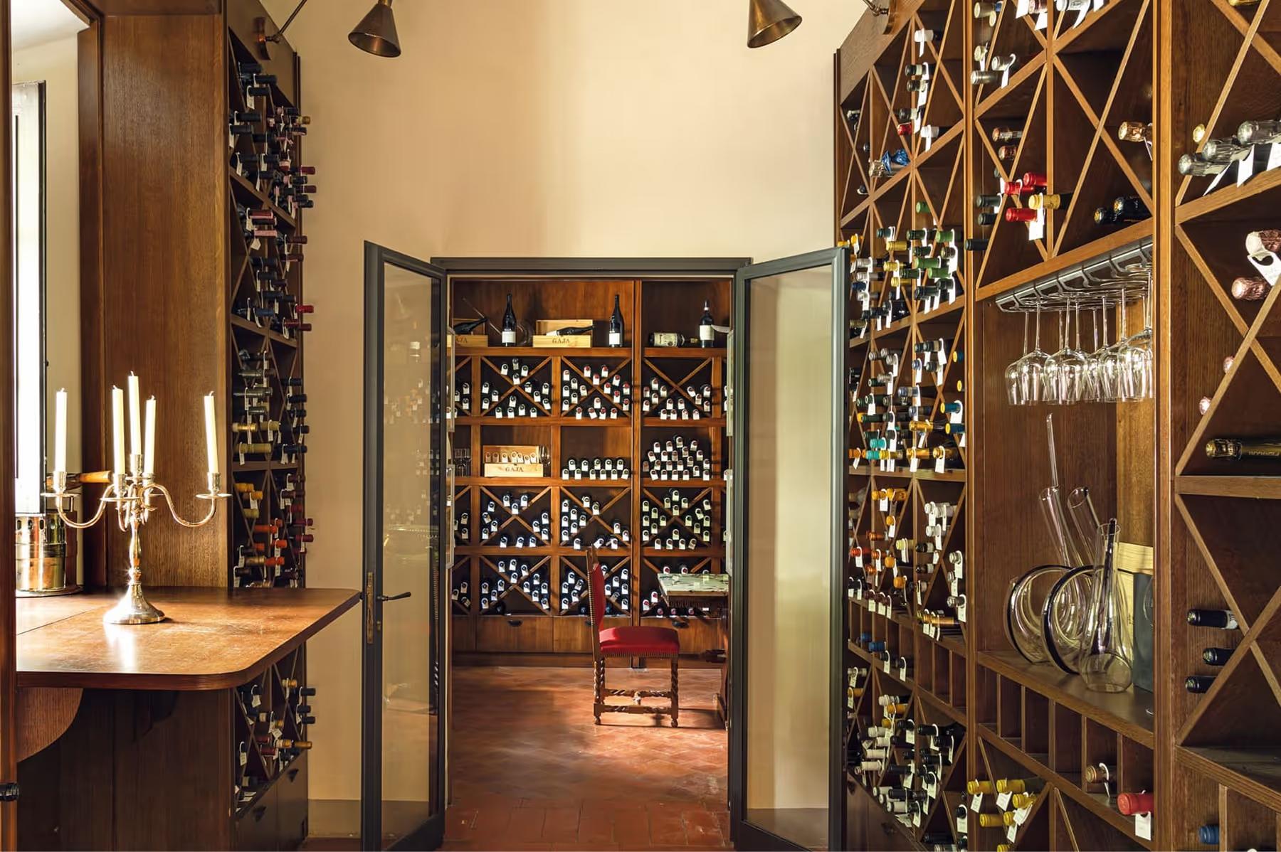 Villa San Michele: a wine cellar entrance with ornate wooden doors and interior wine storage racks visible