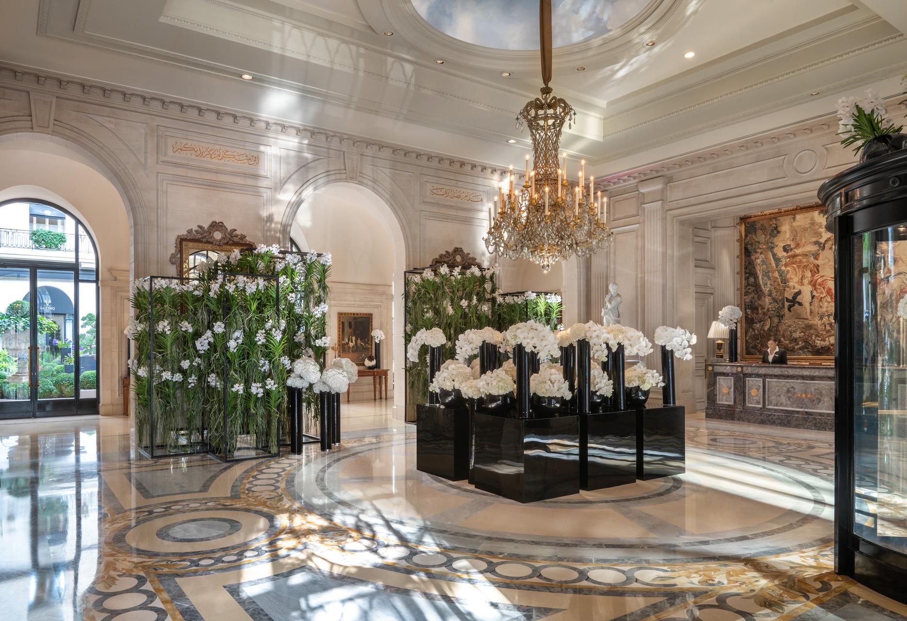 Four Seasons Hotel George V: a bright lobby with cream arches, floral arrangements, and a marble floor pattern