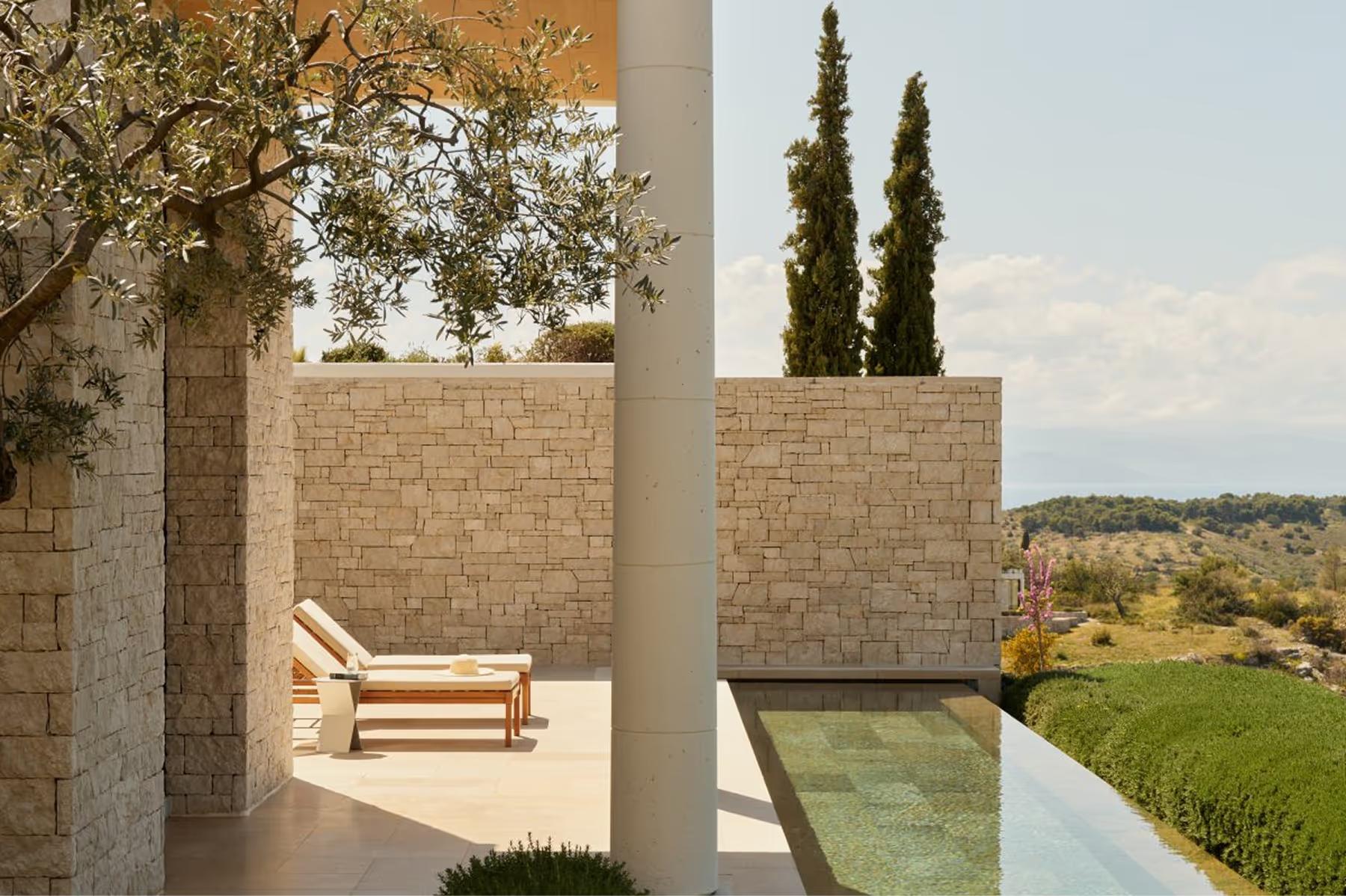 Amanzoe: sheltered courtyard with lounging area overlooking distant blue water