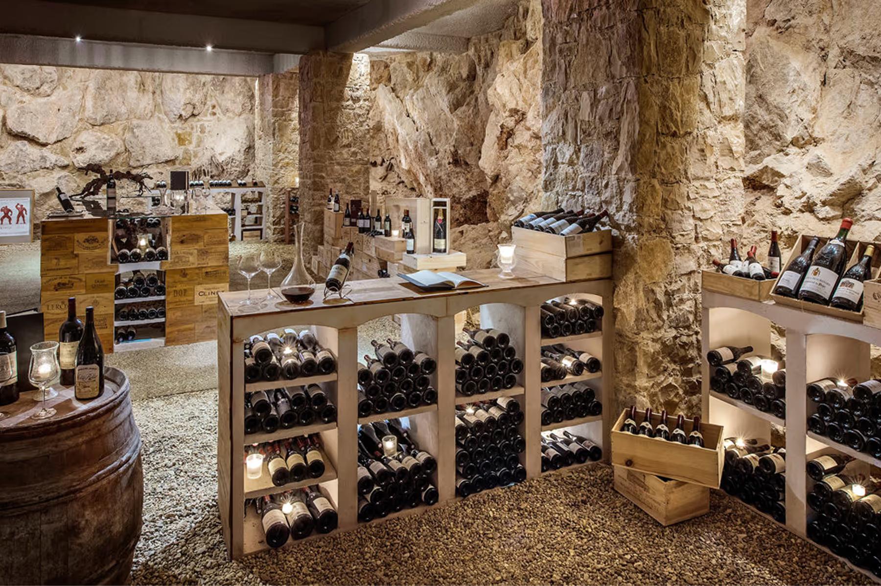 Château Saint Martin & Spa: wine cellar with stone walls displaying bottles in wooden racks