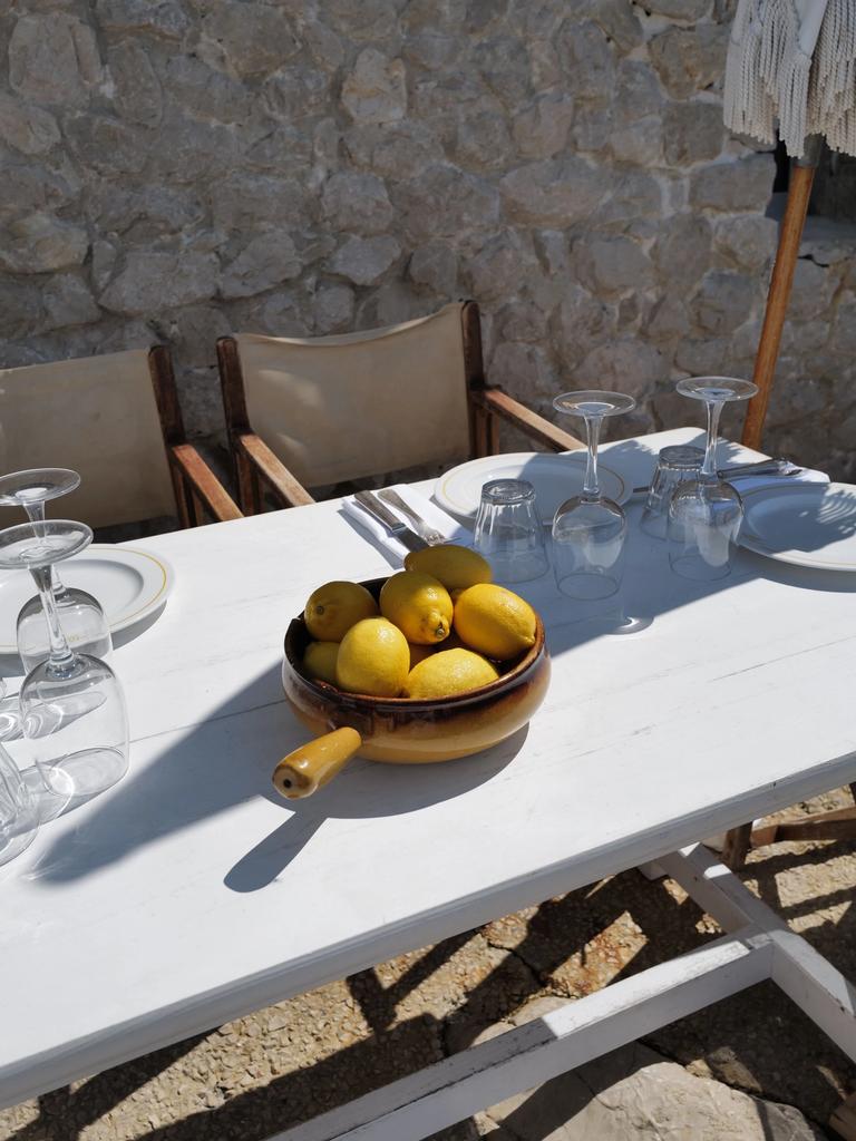 A bowl of lemons on a set table at Tuba Club, against the stone wall