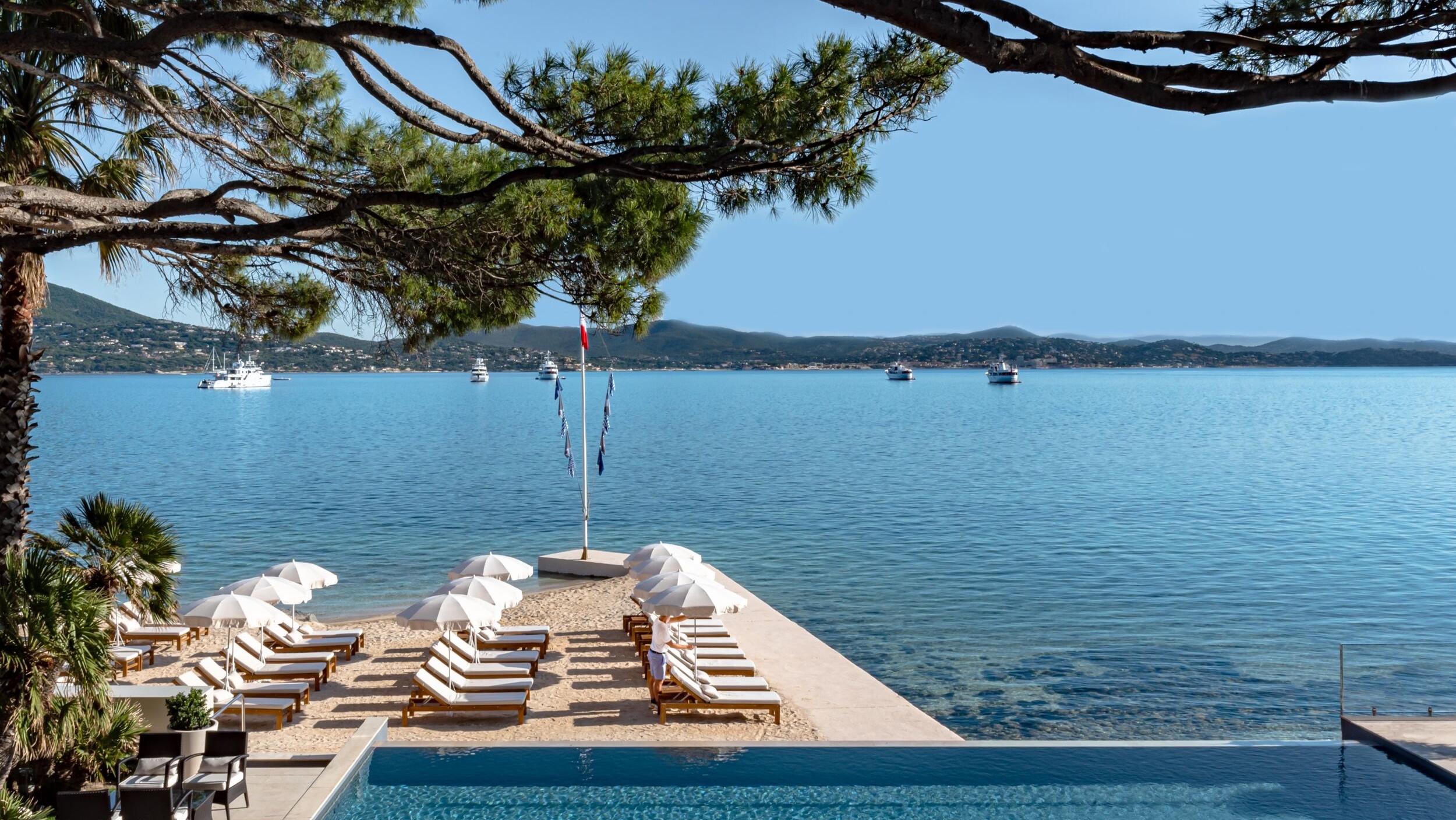 Infinity pool with striped loungers overlooking the Mediterranean