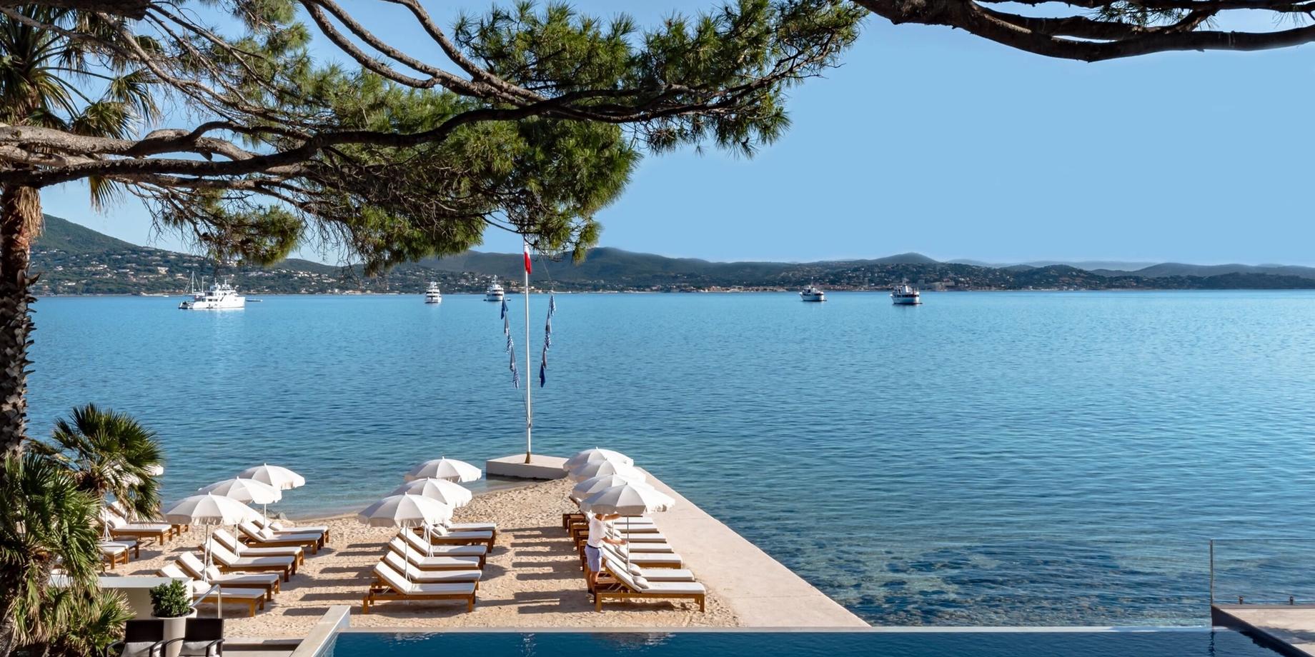Infinity pool with striped loungers overlooking the Mediterranean
