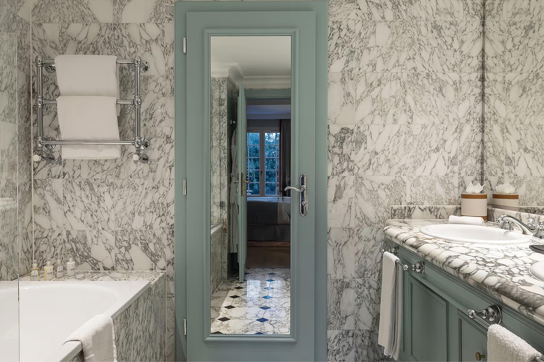 Althoff Villa Belrose: marble-tiled bathroom with seafoam-green accents and vanity mirror