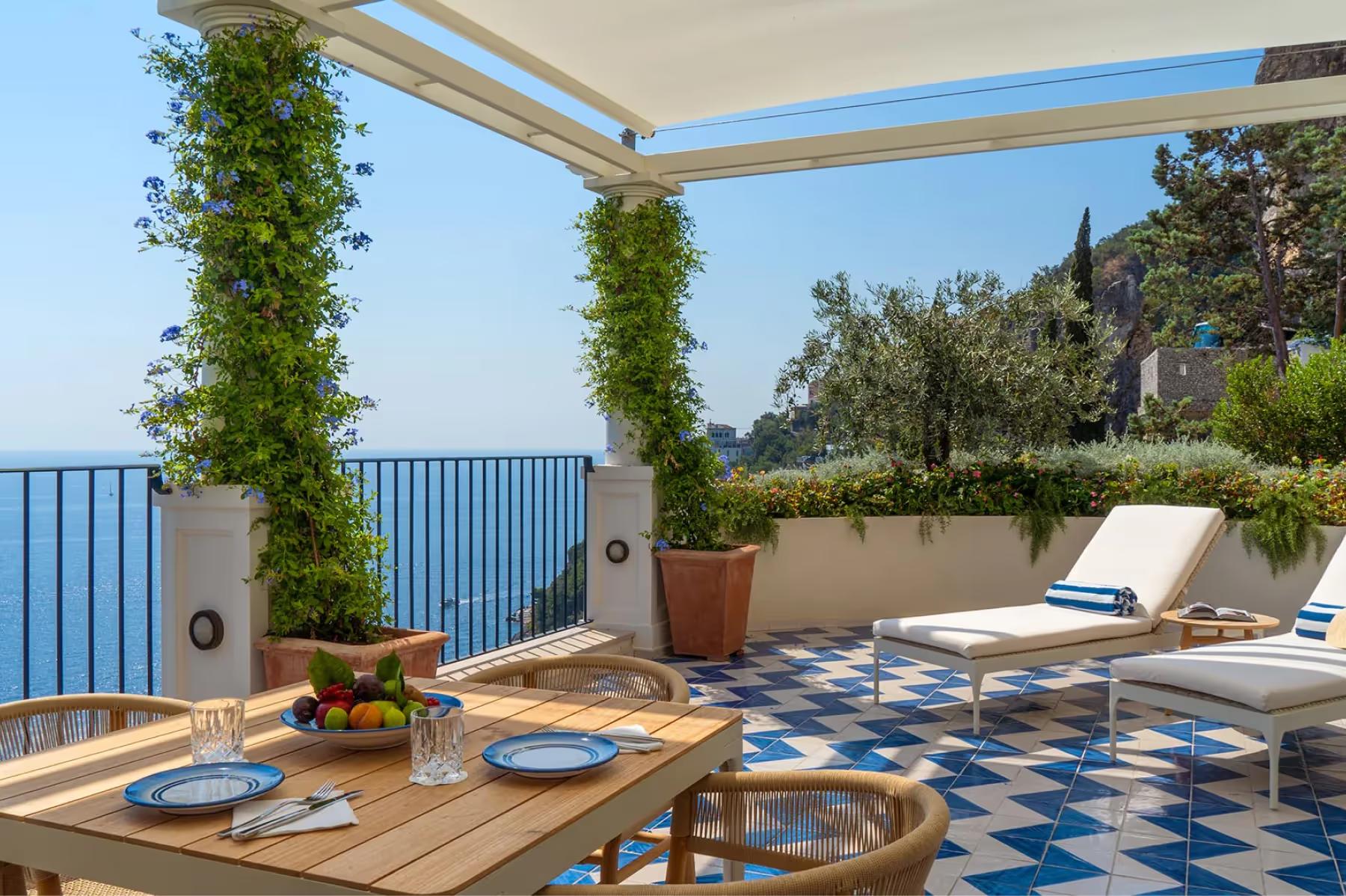 Borgo Santandrea: furnished terrace beneath pergola with climbing ivy and seating overlooking the sea