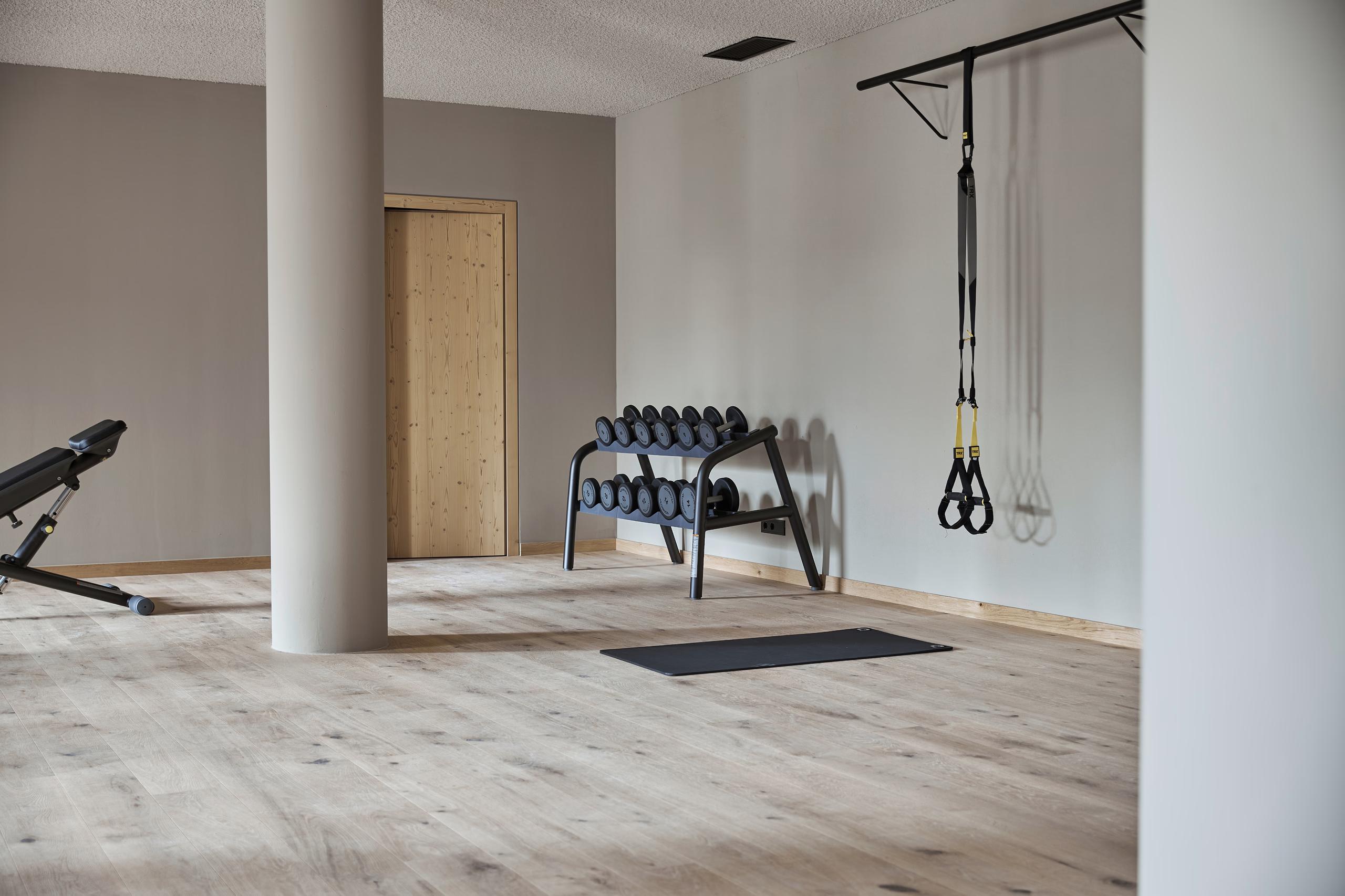 A fitness studio with exercise equipment, wood finishes, and natural light from clerestory windows