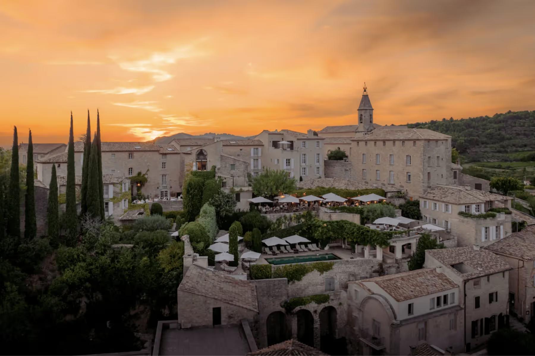 Hôtel Crillon le Brave: the hilltop village at sunset with golden light, stone architecture, and cypress trees against the landscape