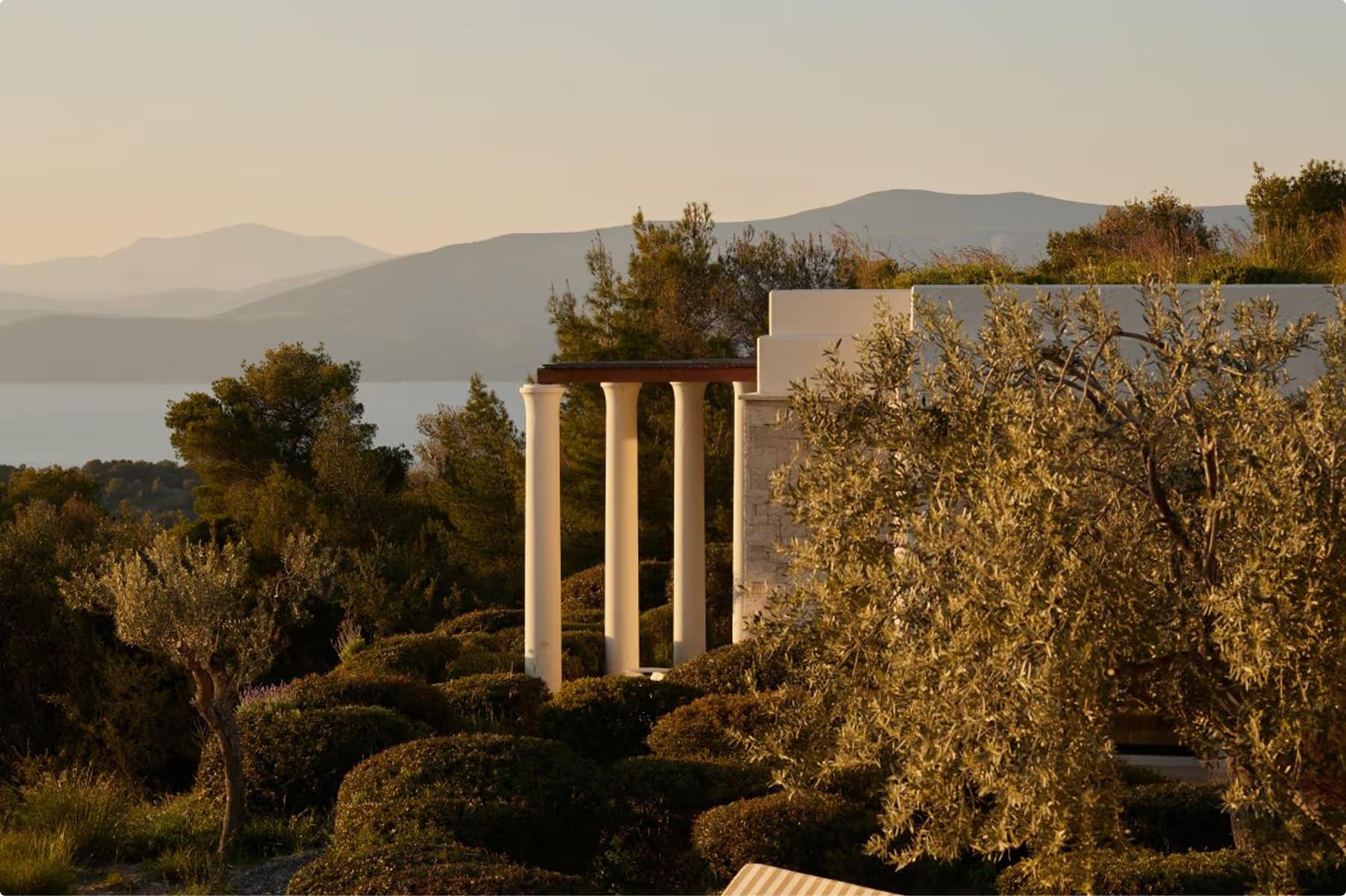Amanzoe: classical columns silhouetted against the Aegean Sea at golden hour